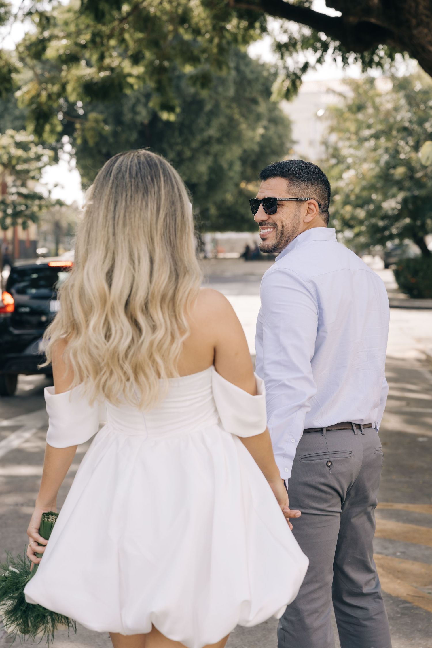 Romantic outdoor photoshoot featuring a white dress and light blue shirt ensemble.