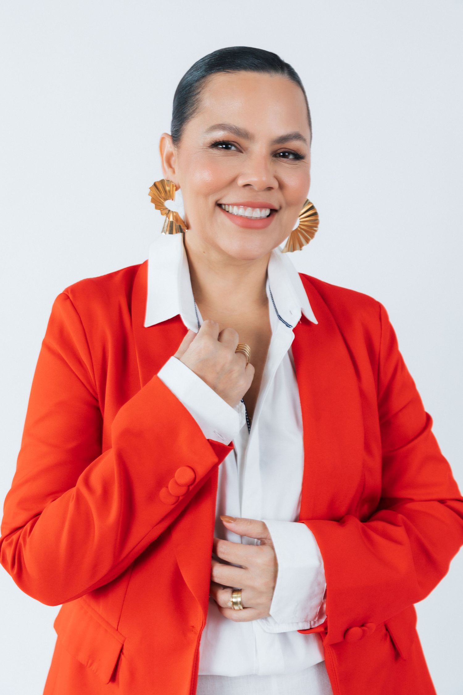 Business portrait featuring a bright red blazer, white shirt and eye-catching gold fan earrings.