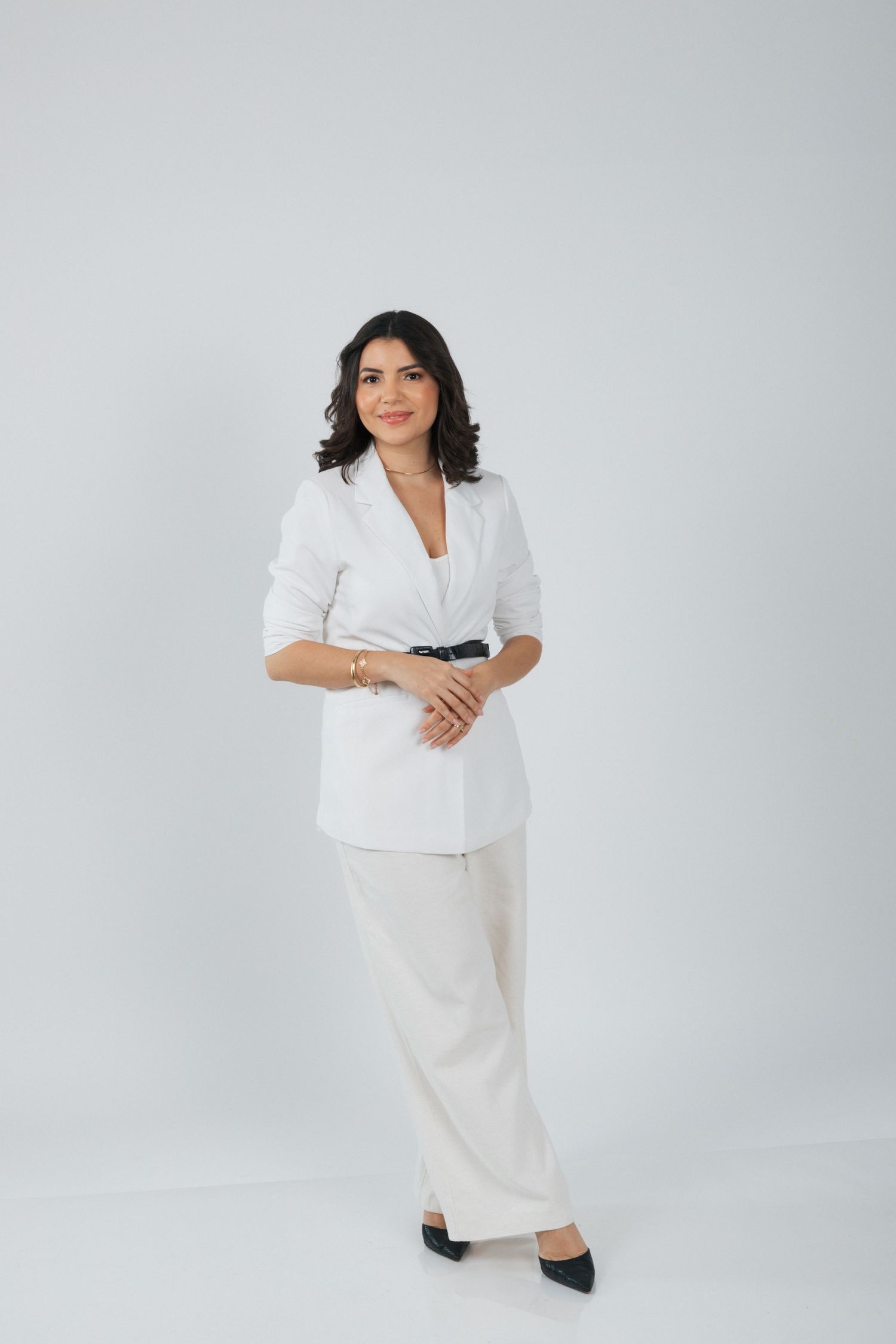 Professional full-length portrait in crisp white blazer and wide-leg trousers.