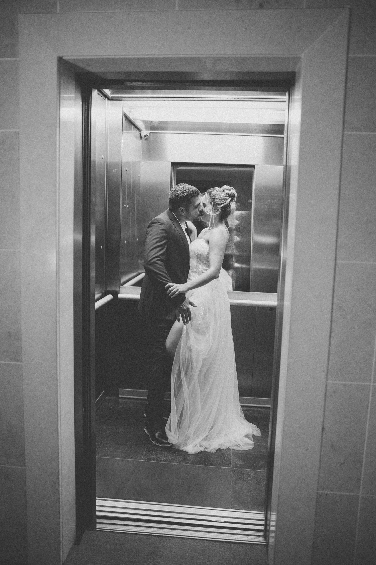Black and white romantic moment captured inside an elevator.