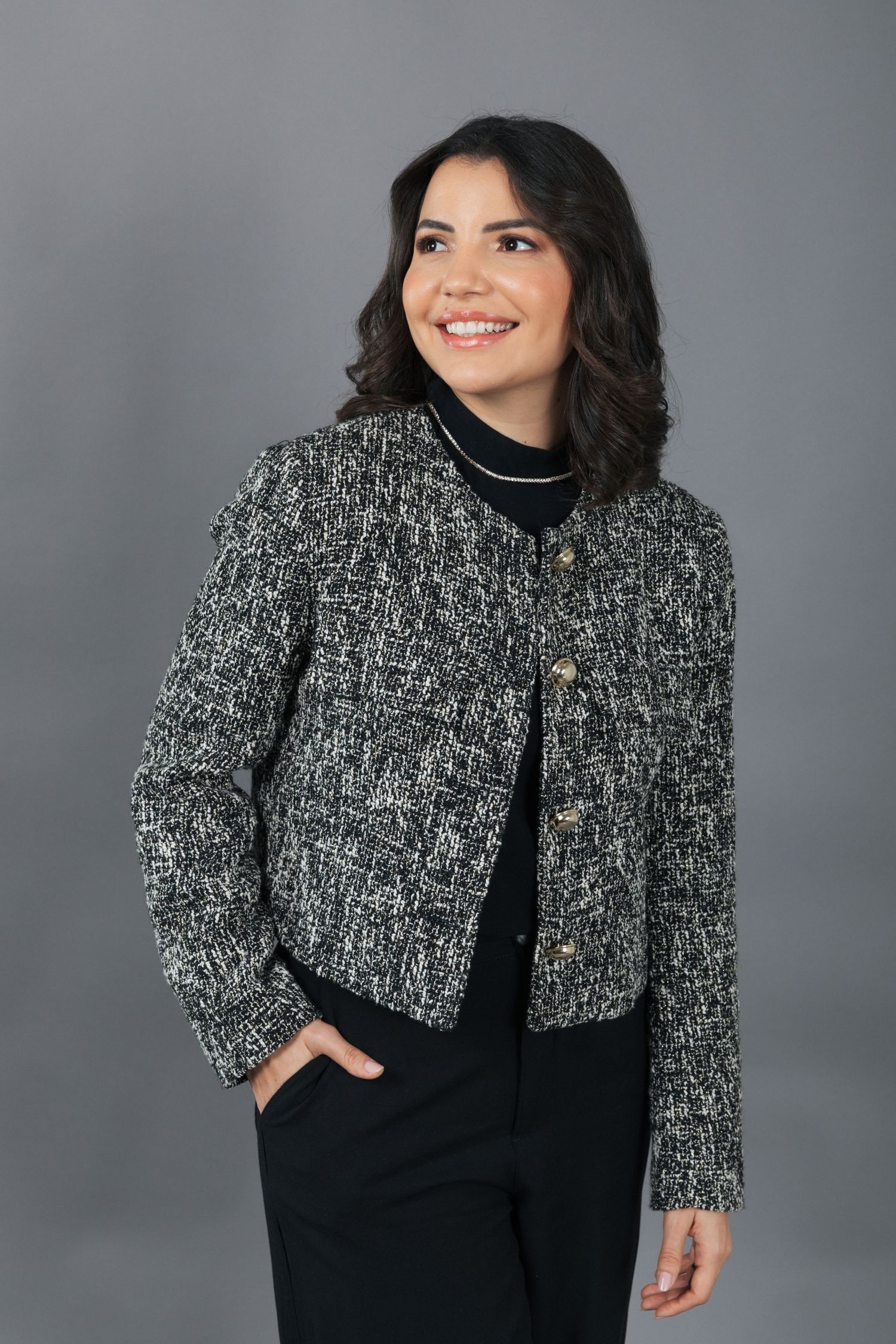 Professional studio shot showcasing textured gray jacket over black ensemble.