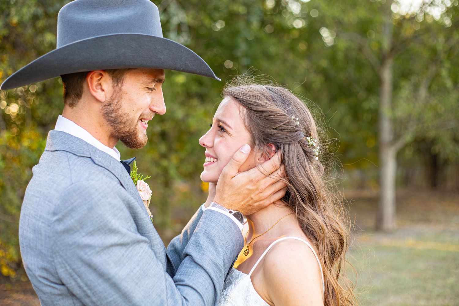 Tender moments between newlyweds captured in natural outdoor setting.