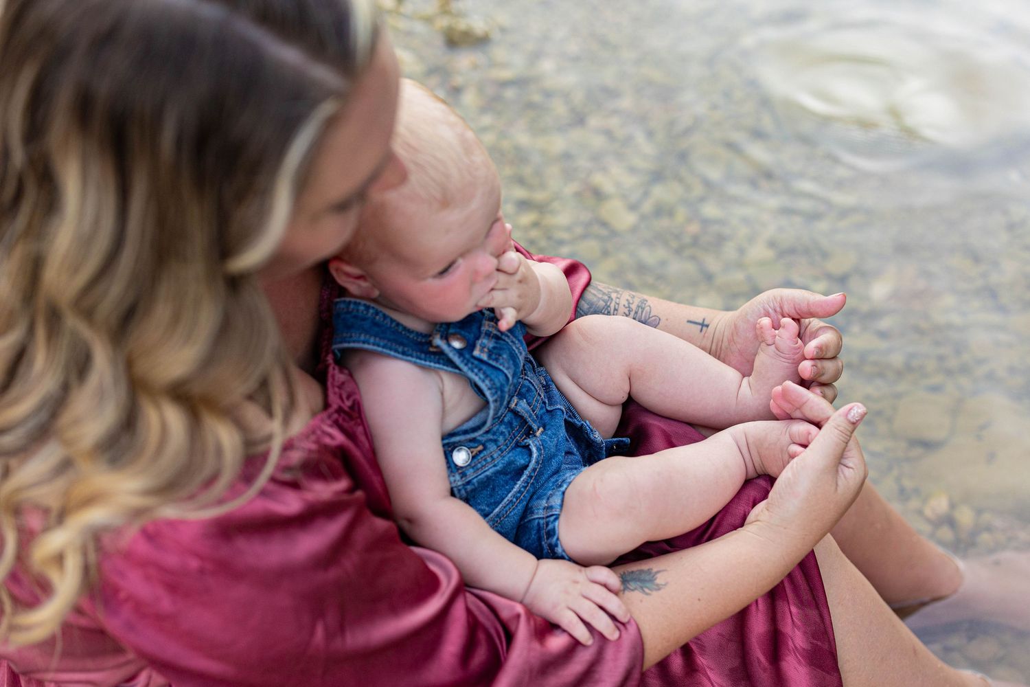 An intimate moment shared by the water's edge with pink and denim clothing.