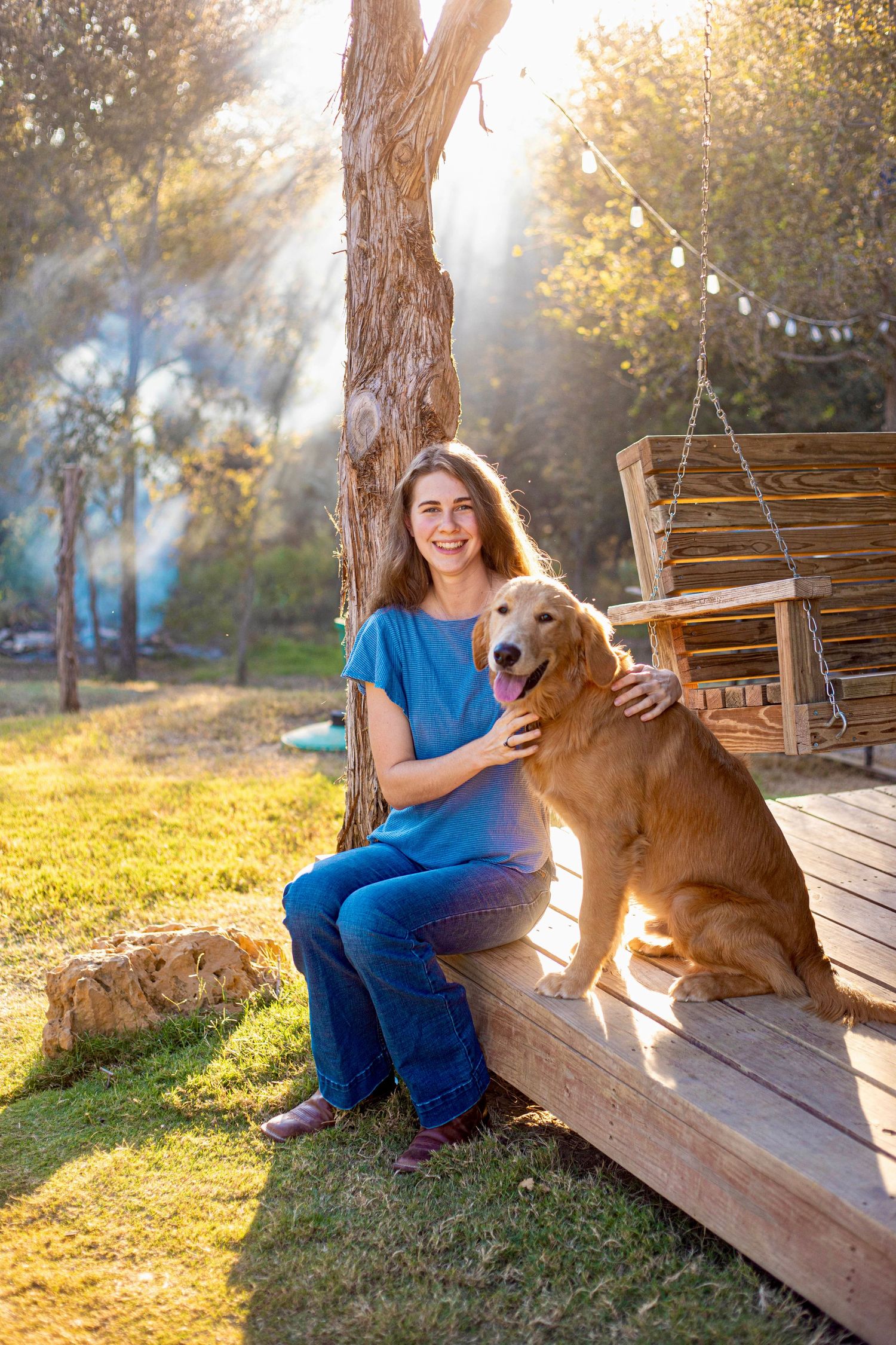 A Golden Retriever and companion sitting on a wooden deck during a sunny afternoon.