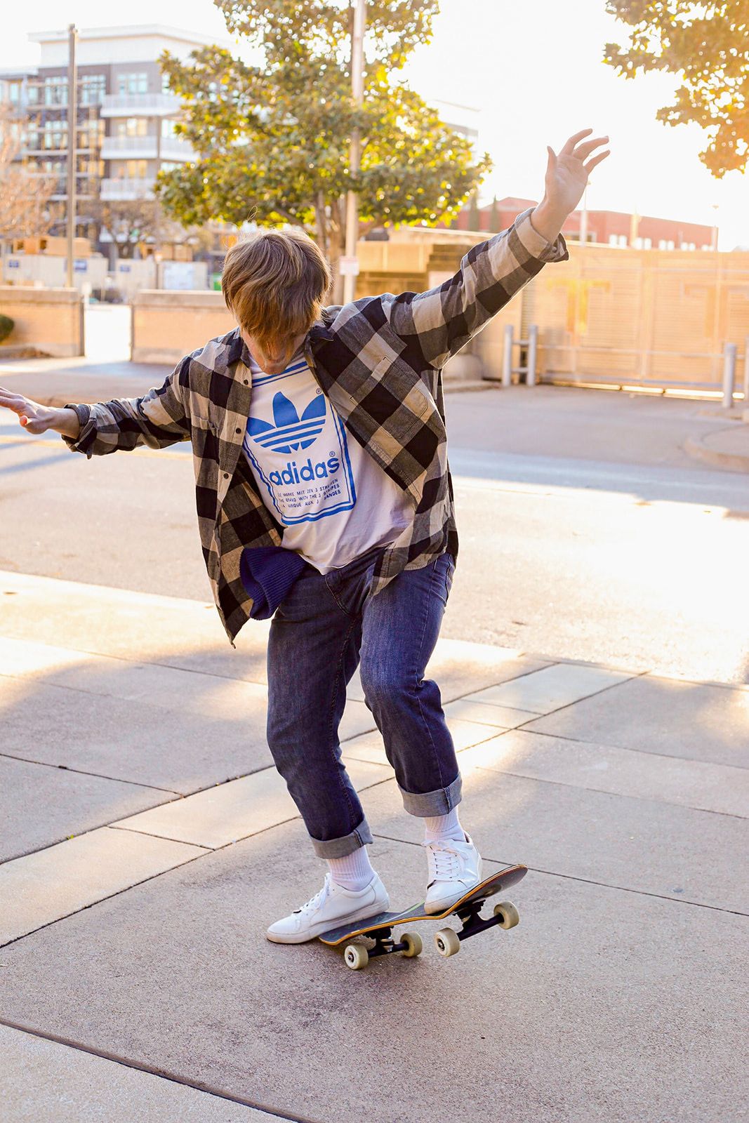A sequence showing skateboarding tricks being performed in a plaid shirt and jeans on concrete.