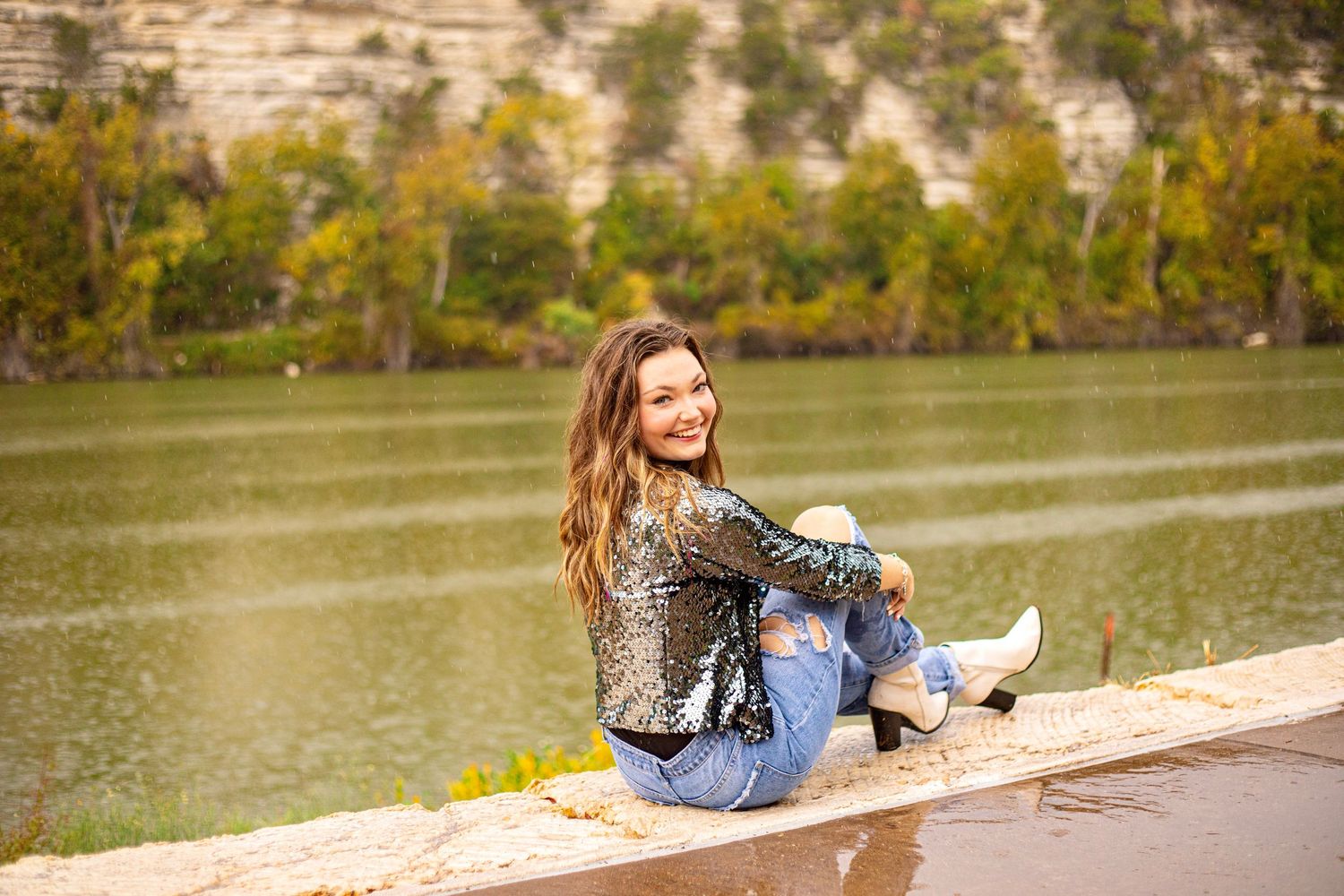 A candid lakeside photoshoot showing someone relaxing by the water's edge.