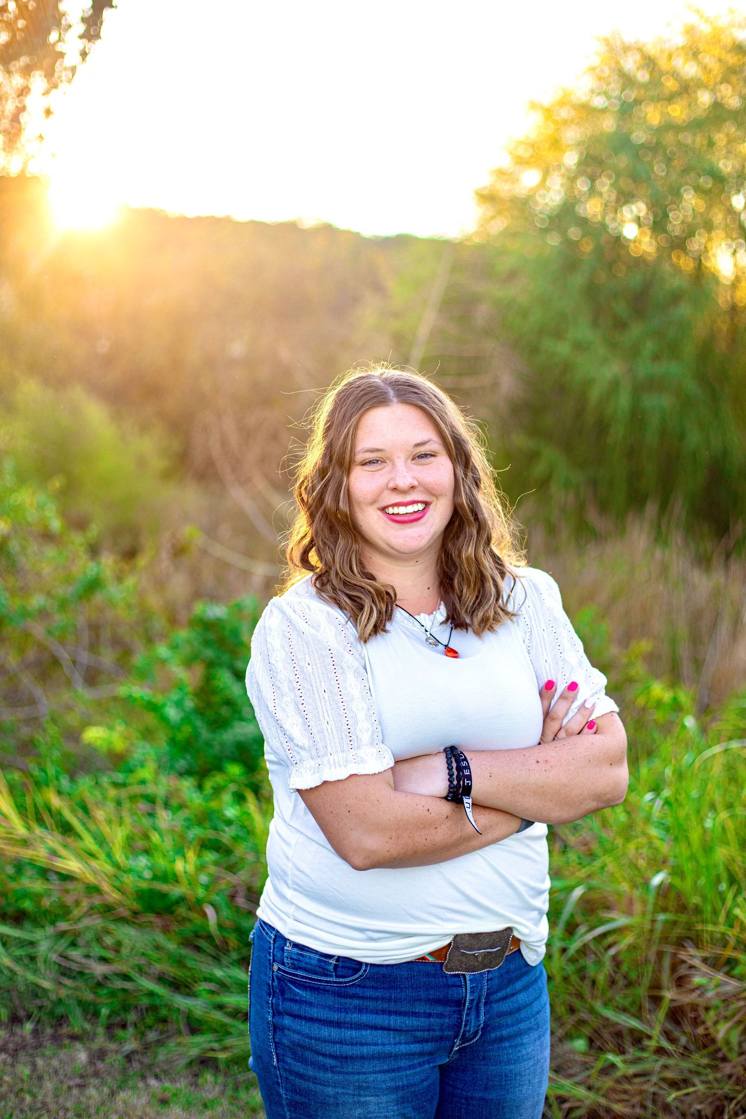 A casual portrait session in a natural setting with warm sunset lighting and greenery.