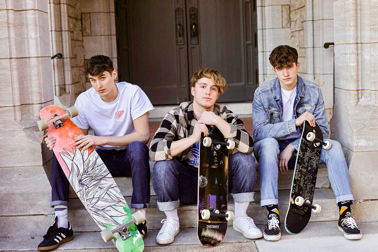 Group of skateboarders sitting and relaxing on stone steps.