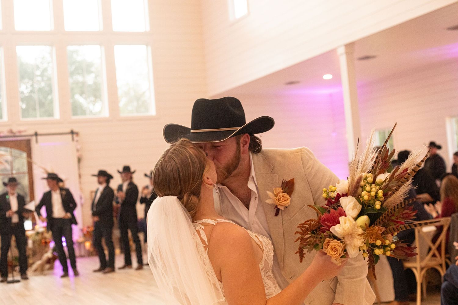 Romantic first dance moment at wedding reception in bright indoor venue.