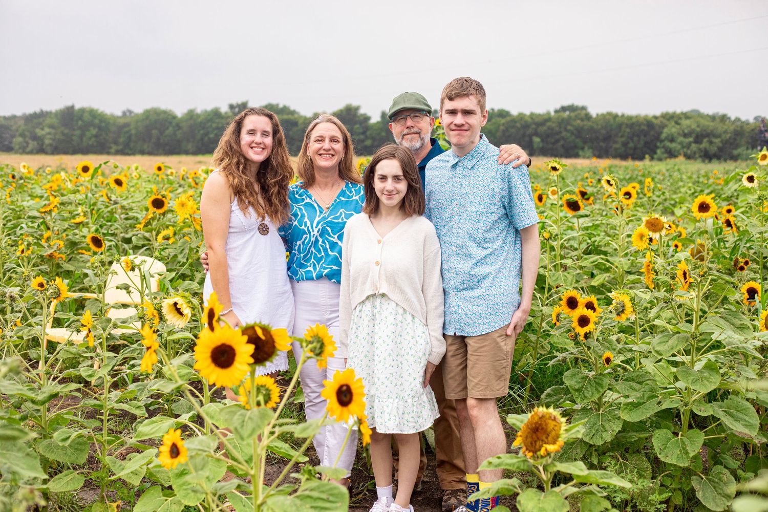 Group photo session in a vibrant sunflower field during golden hour.