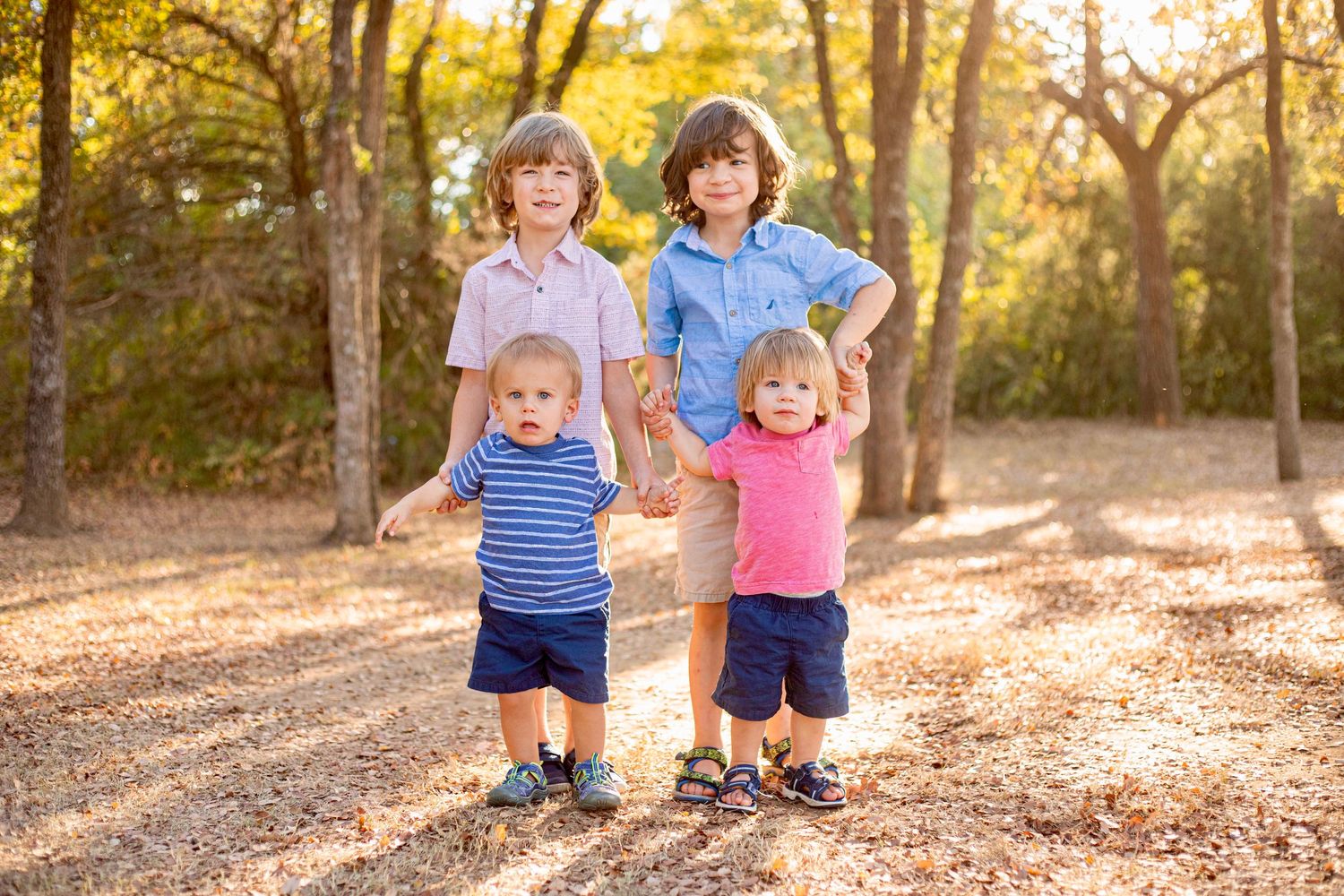 Children playing and running through a forest with golden sunlight streaming through trees.