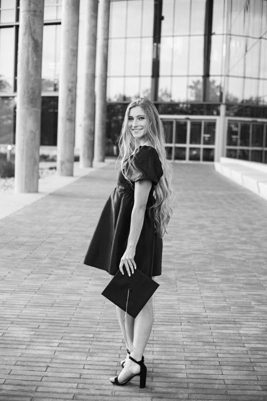 Modern architecture featuring tall columns and glass windows in black and white photography.