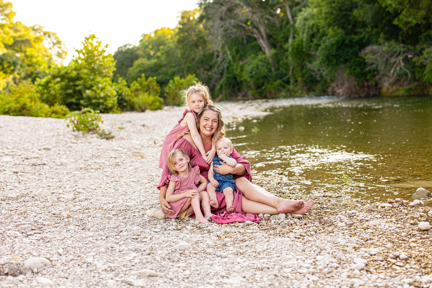 Candid family photos taken along a scenic riverbank with lush green backdrop.