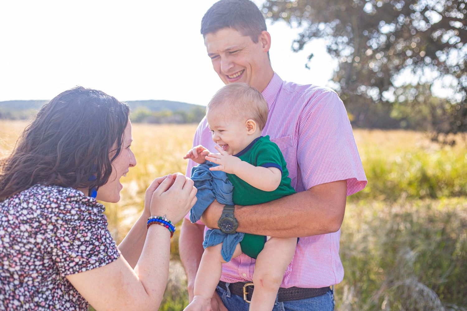 Joyful interactions between family members in a sunlit meadow.