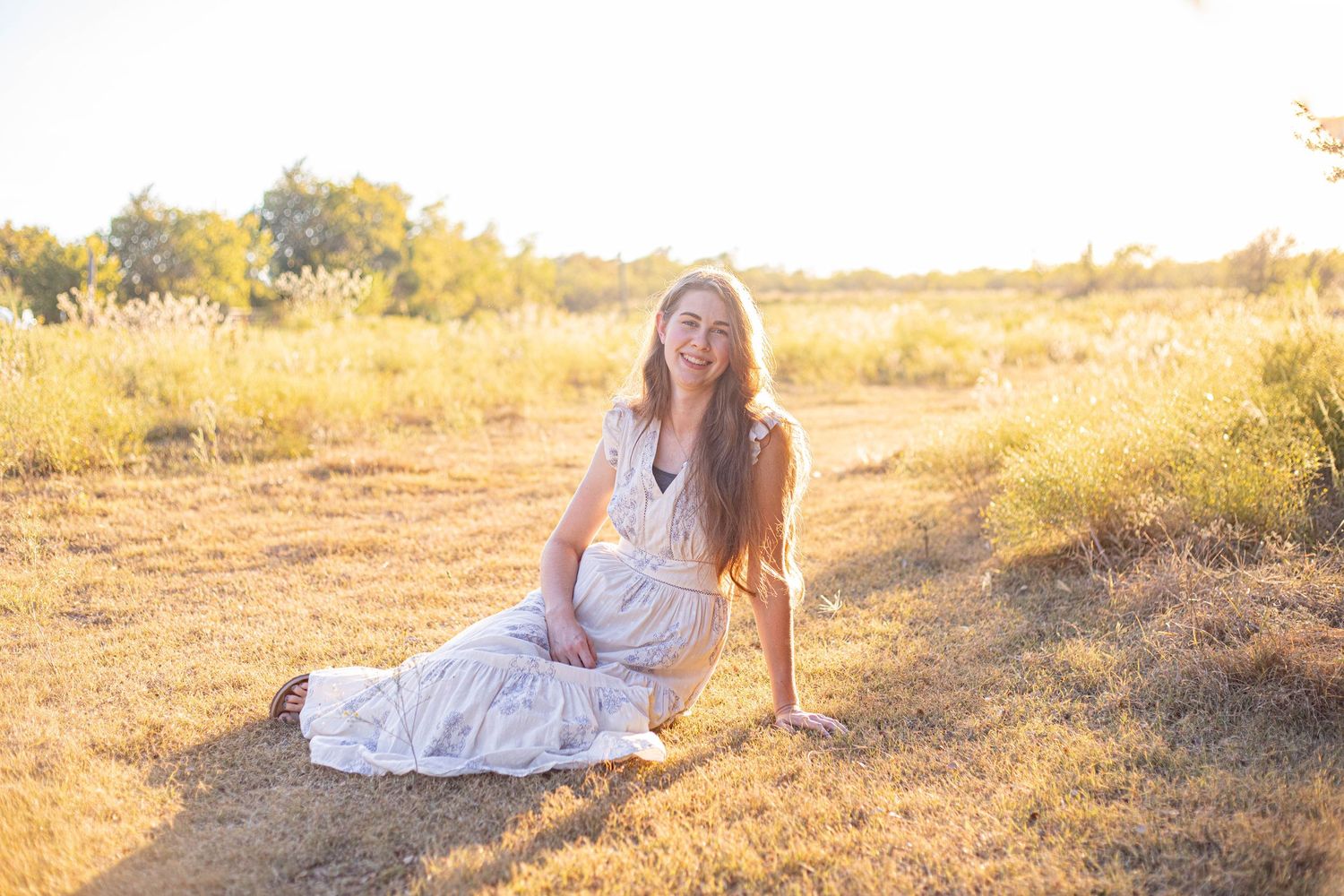 Sunset portrait session in natural outdoor setting with warm lighting.