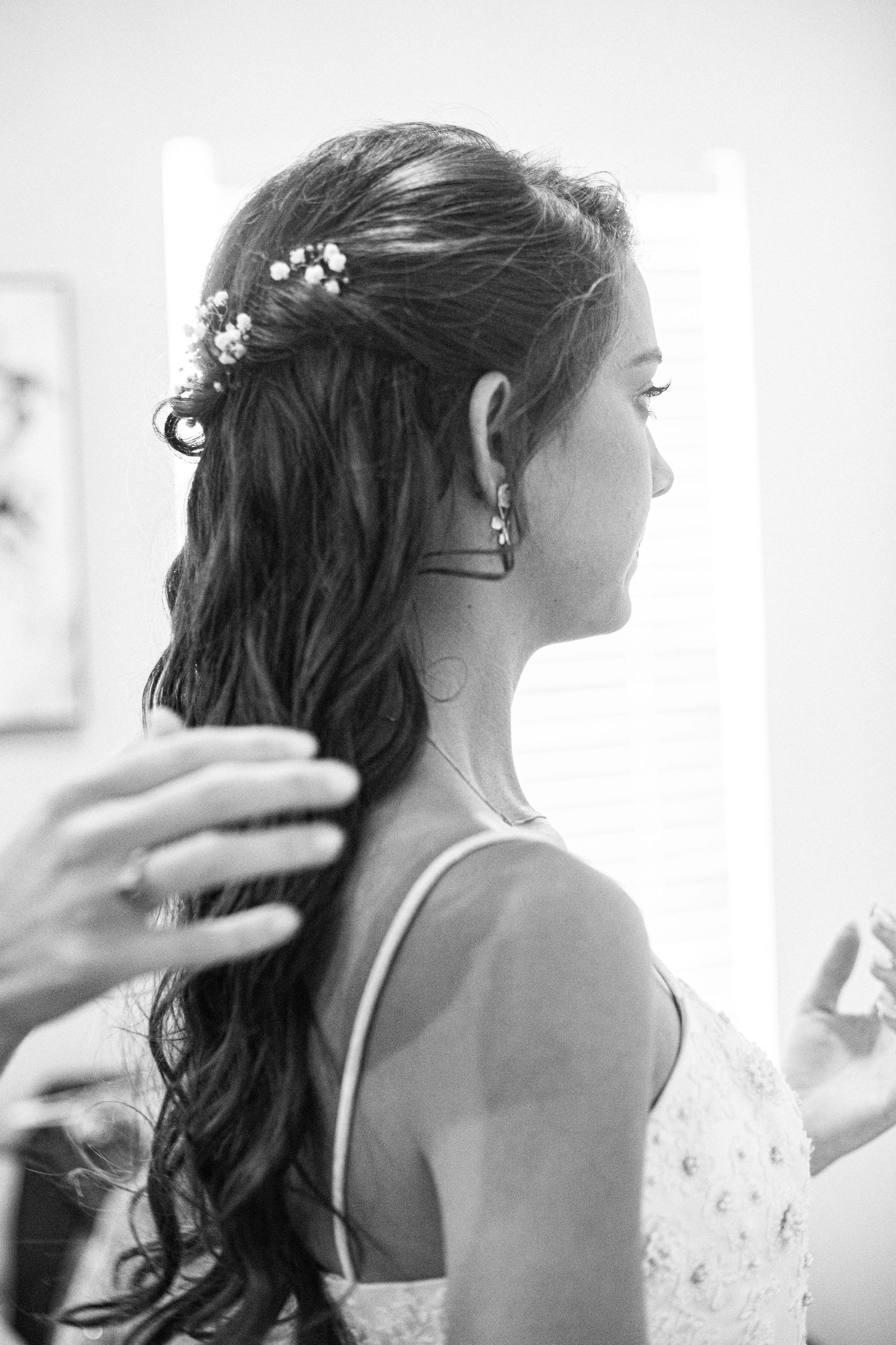Black and white close-up of bridal hairstyling with delicate hair accessories.