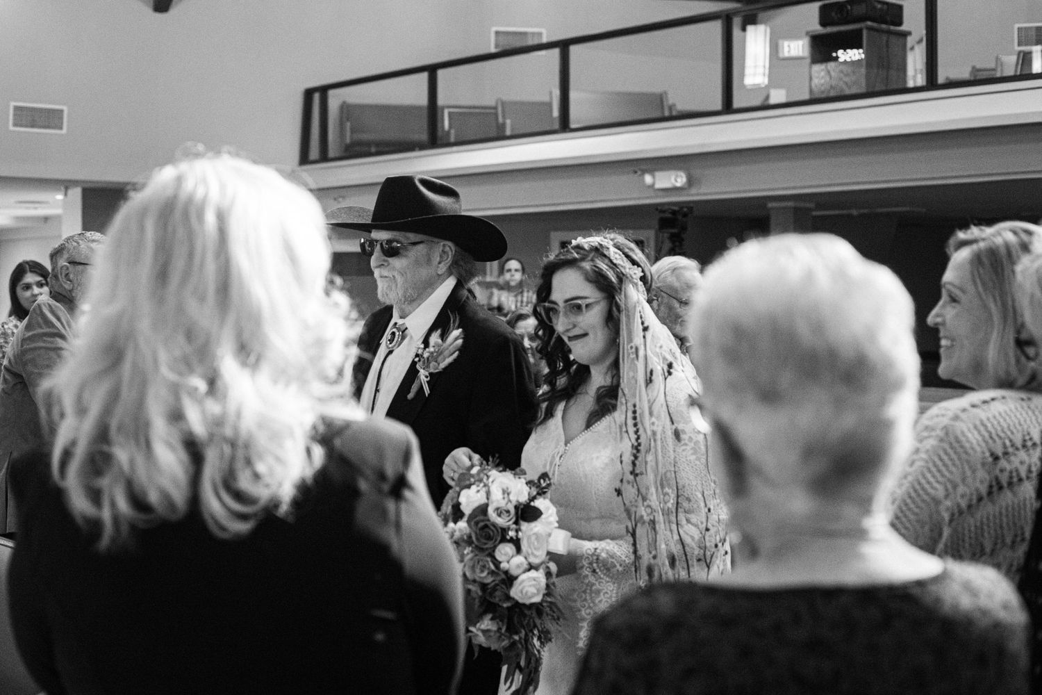 Black and white candid moment during wedding reception with guests.