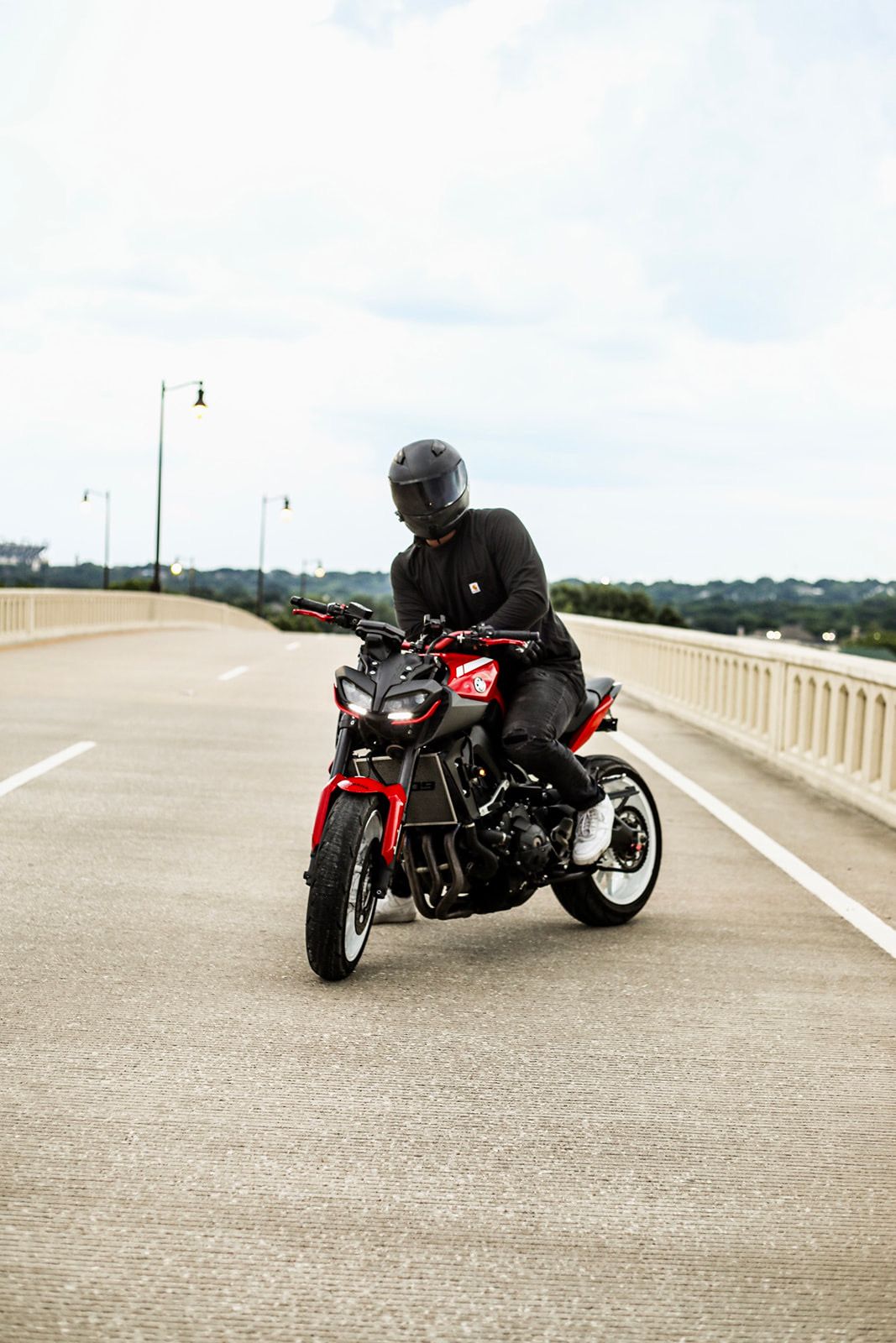 Red motorcycle photographed from different angles on an empty concrete bridge.