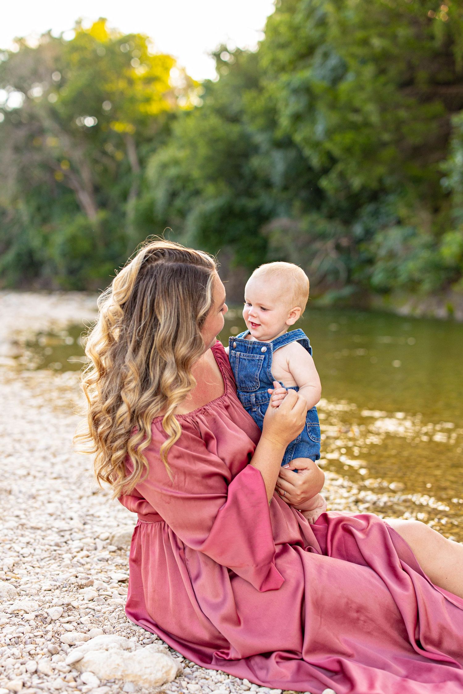 Sweet moment captured on a rocky riverbank during golden hour.