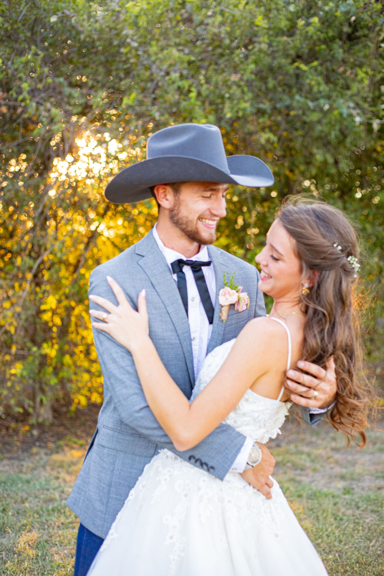 Romantic couple shares intimate moments during sunset wedding photoshoot in outdoor setting.