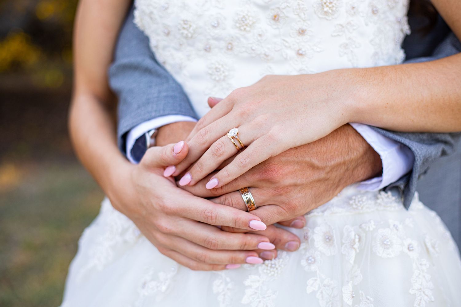 Close-up details of wedding rings and hands showing romantic gestures.