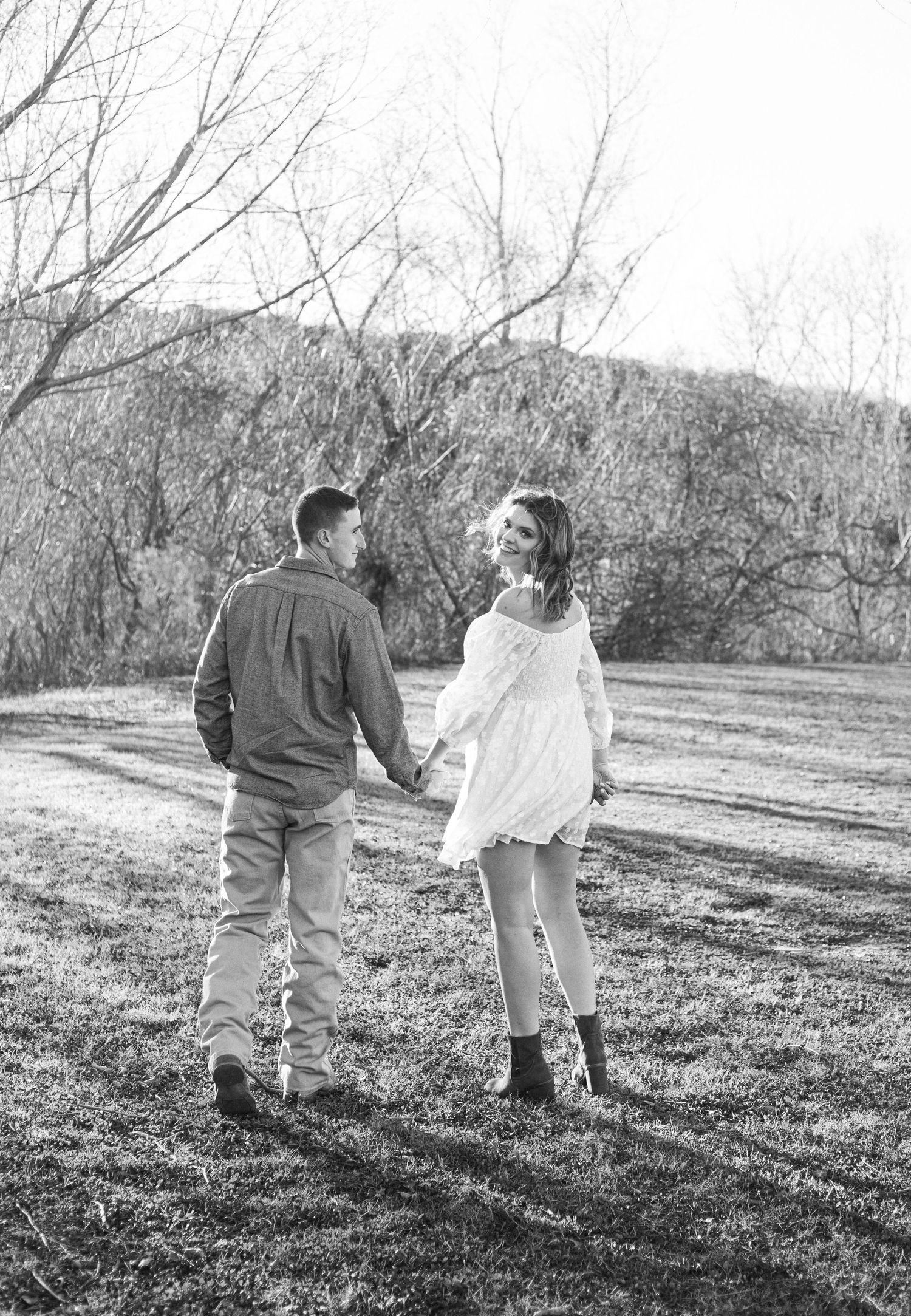 Black and white couple's portrait walking together in natural setting.