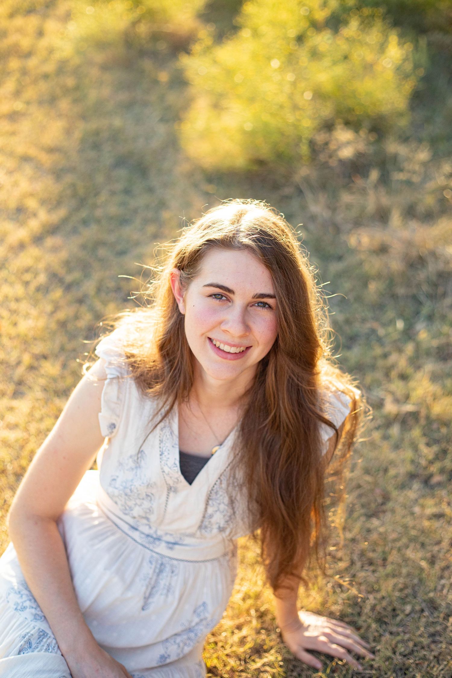 Candid expressions captured in white dress during golden hour photoshoot.