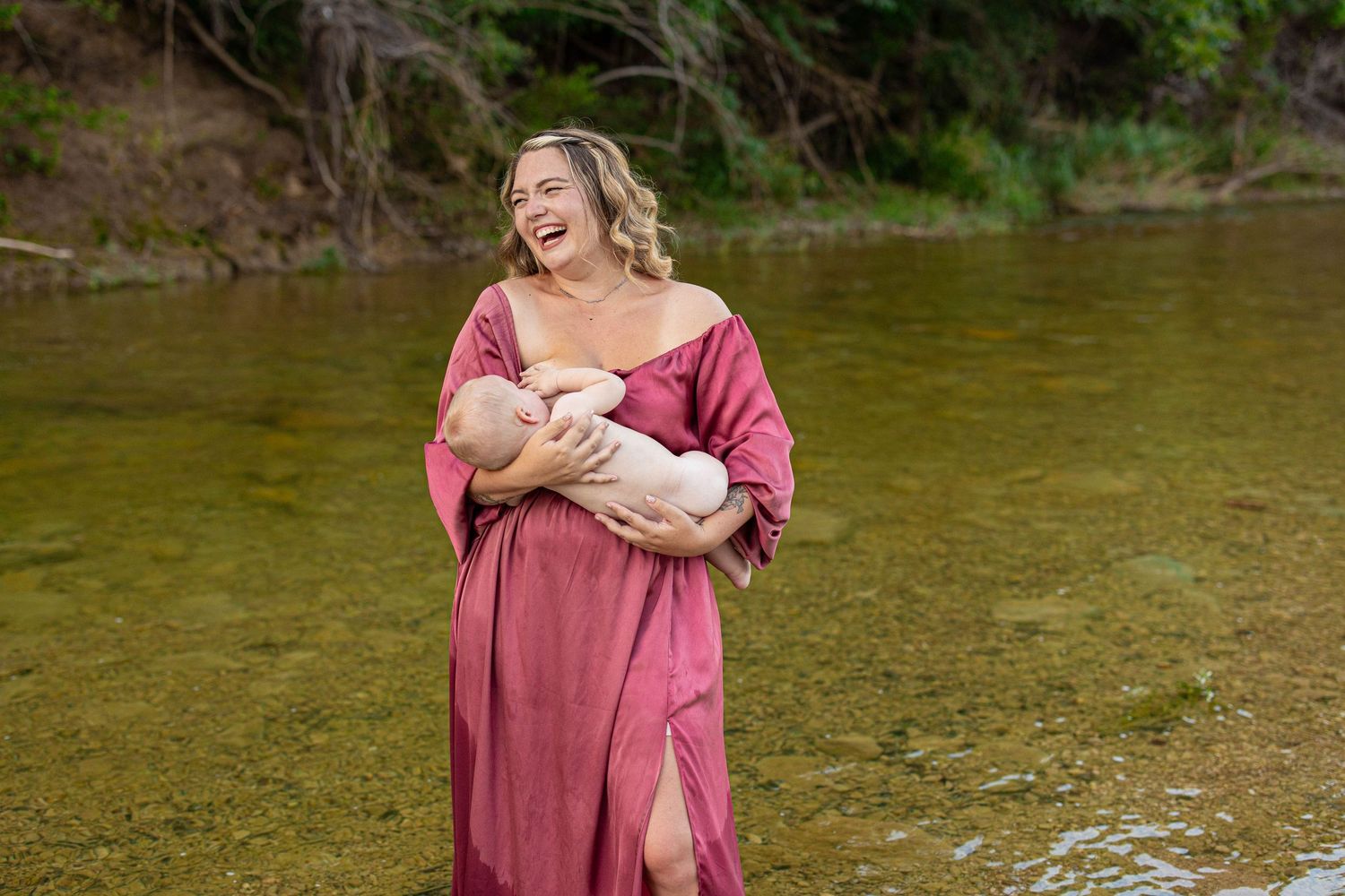Playful moments captured in a flowing pink dress near the water.