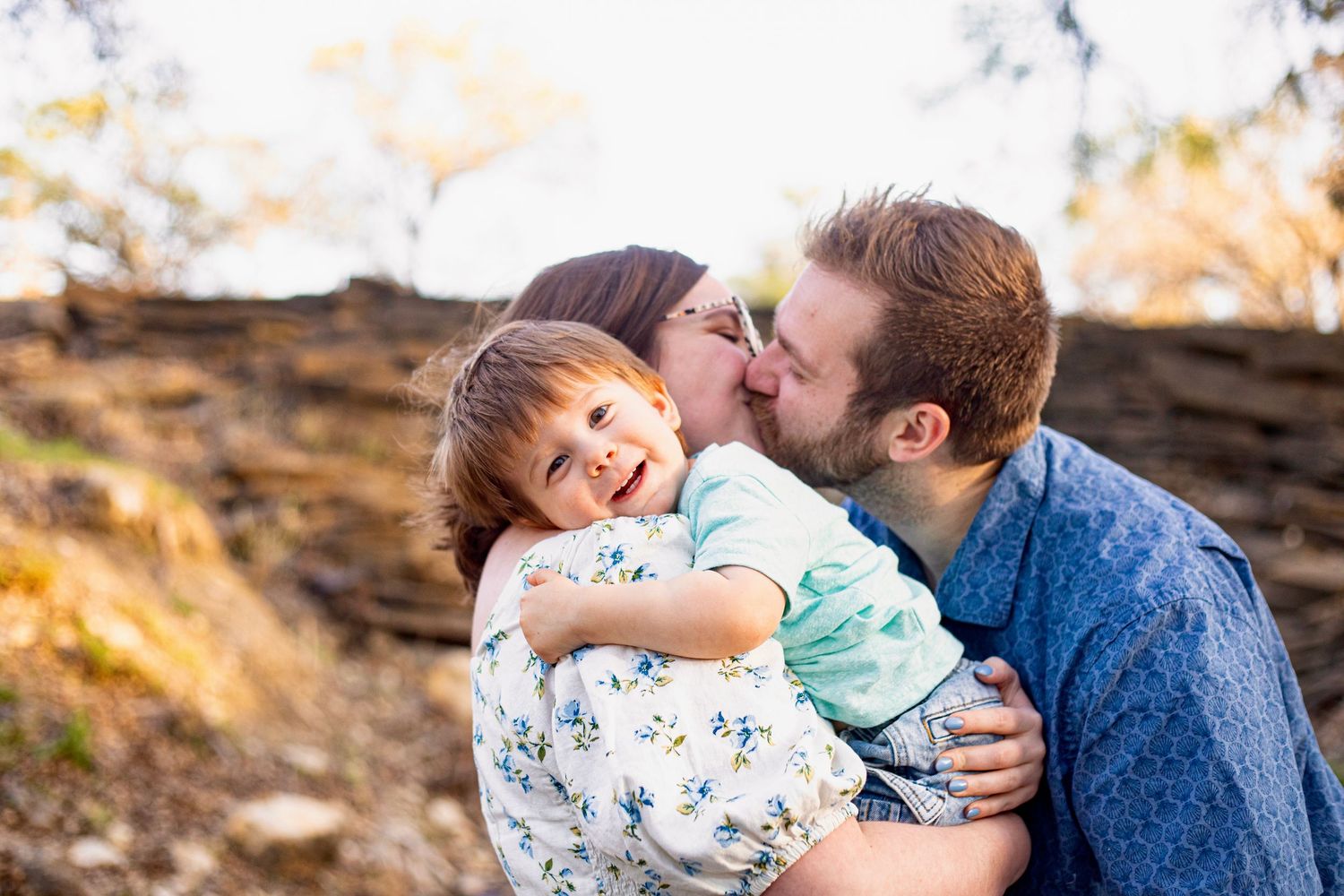 A tender family moment captured outdoors during golden hour.