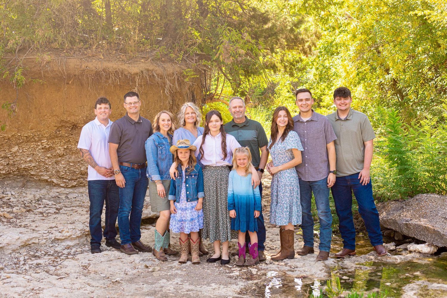 Extended family group photos in a natural outdoor setting with golden lighting.