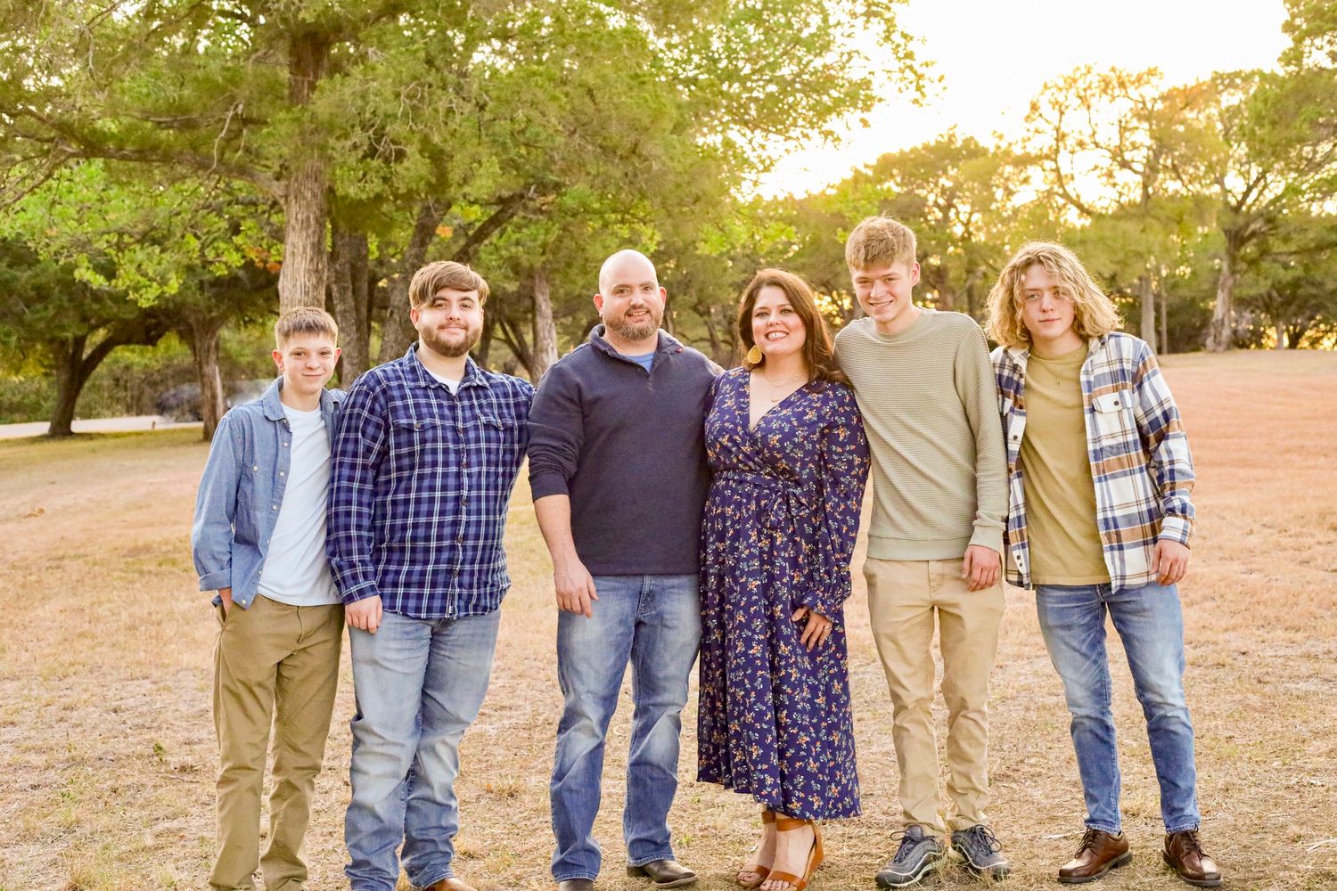 Extended family group photo in casual attire against natural outdoor setting.