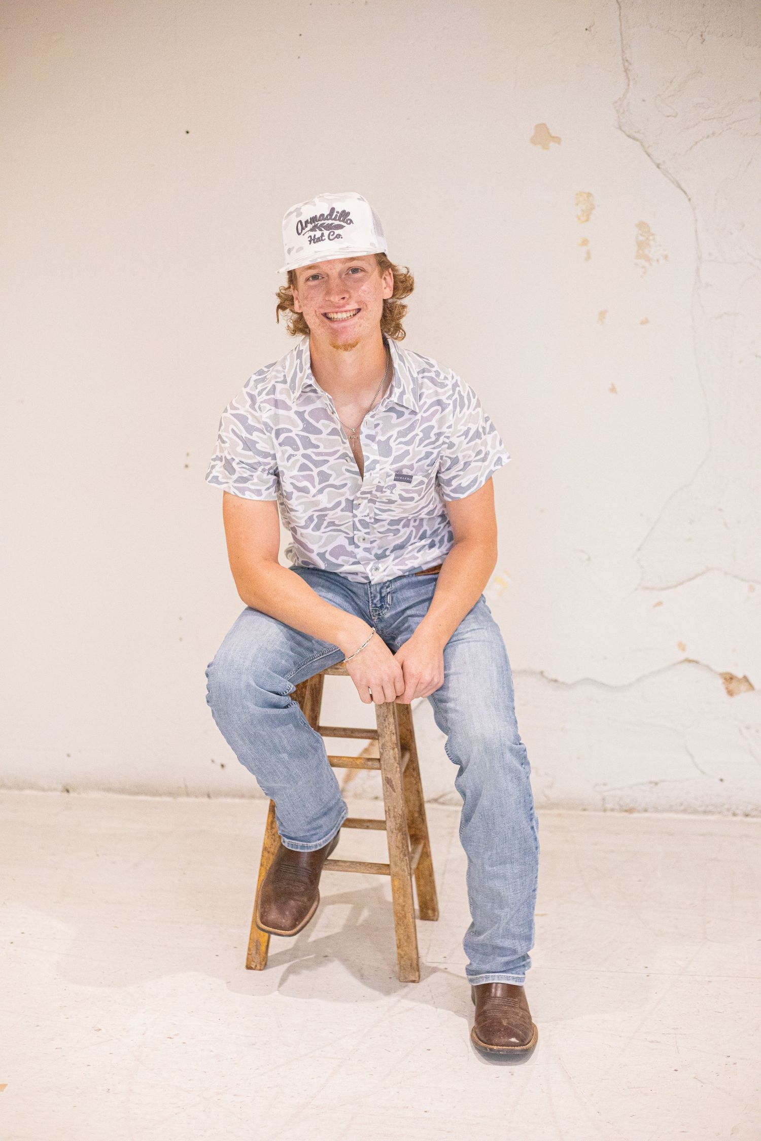 Casual studio portraits against a white backdrop featuring denim and western wear styling.