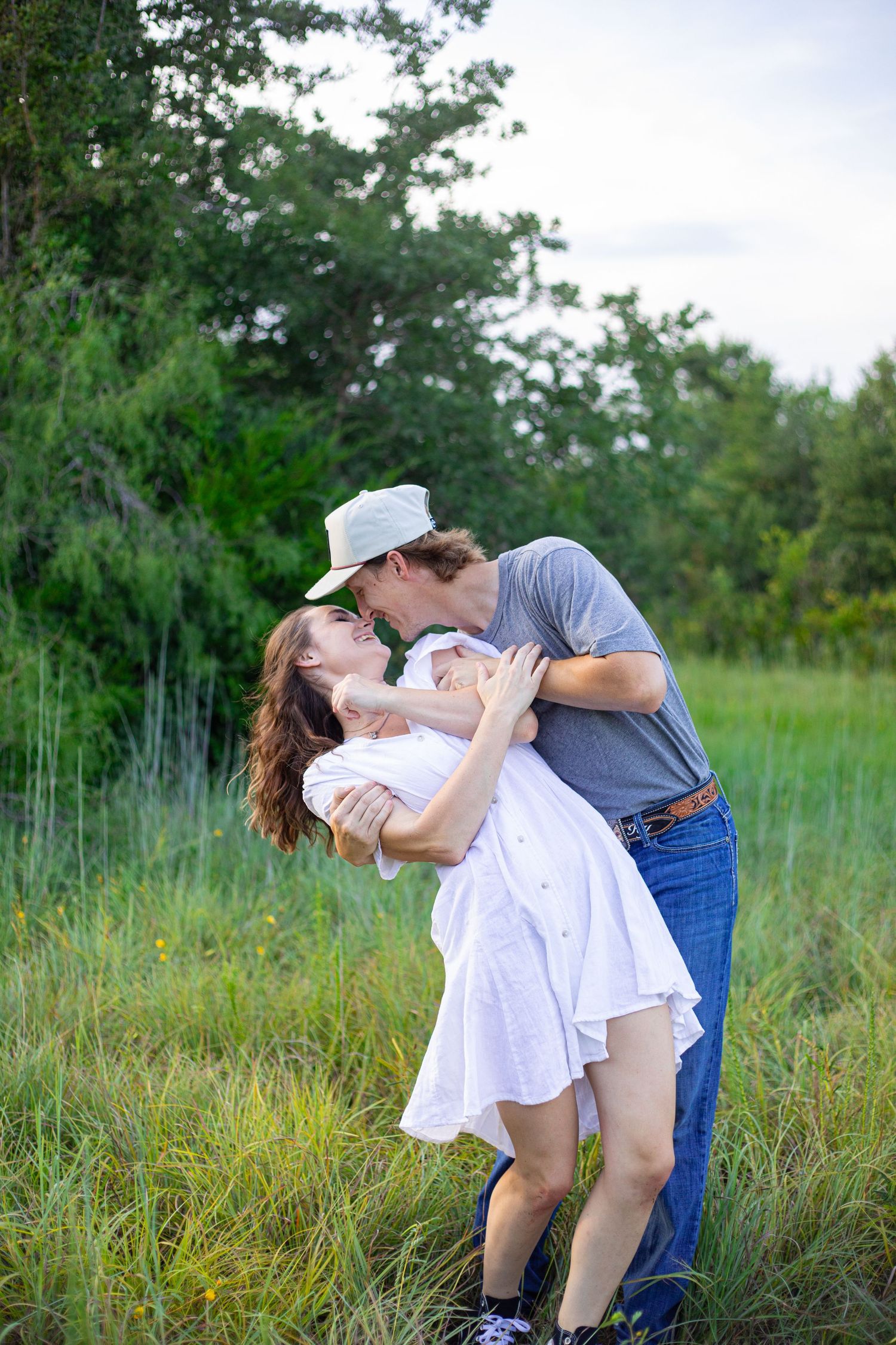 Romantic couple sharing tender moment in summer meadow.