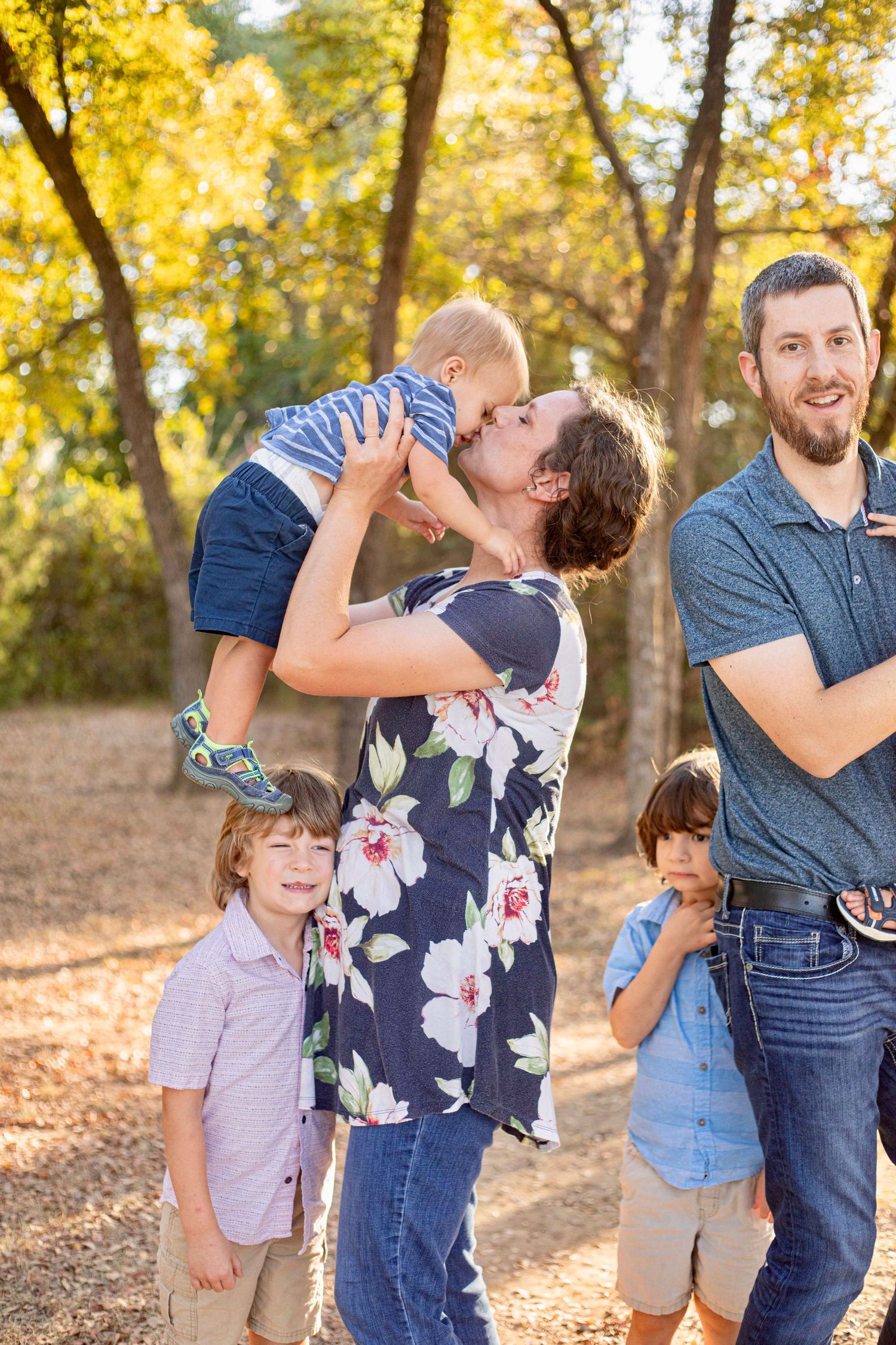 A loving family moment captured during an outdoor autumn photoshoot.