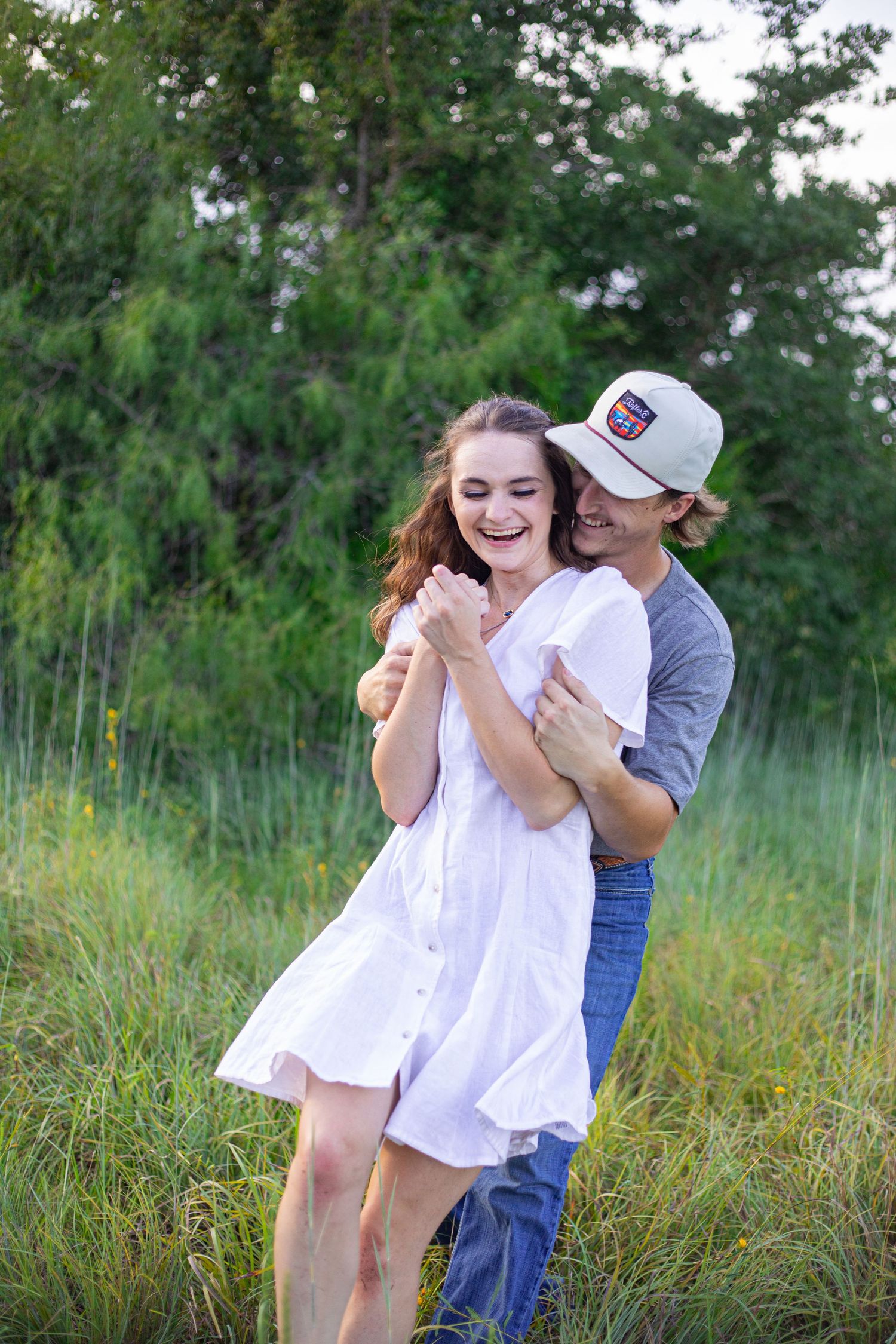 Couple sharing intimate moment while standing in tall grass.