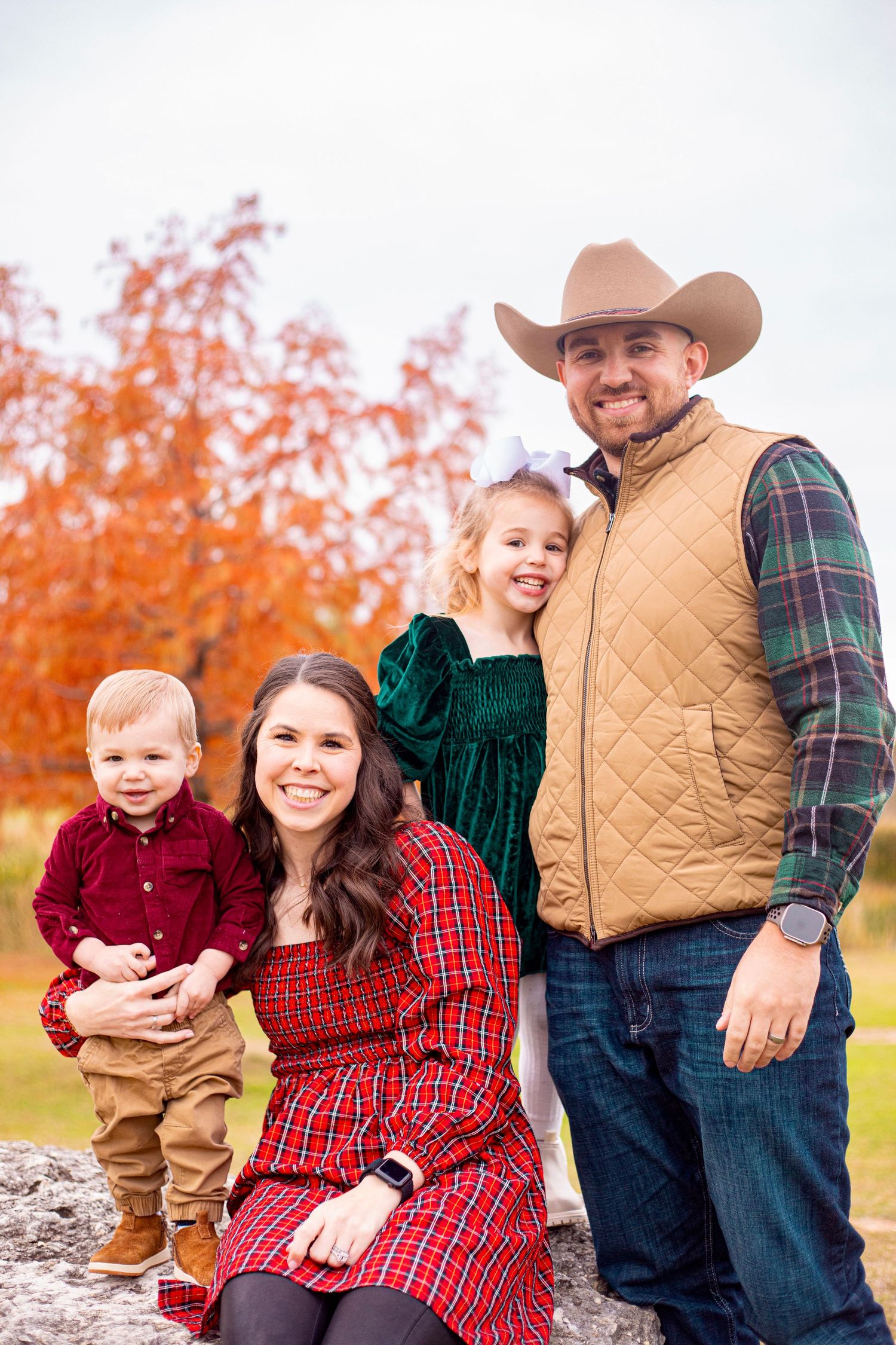 Fall family portraits featuring western wear and plaid against autumn foliage.
