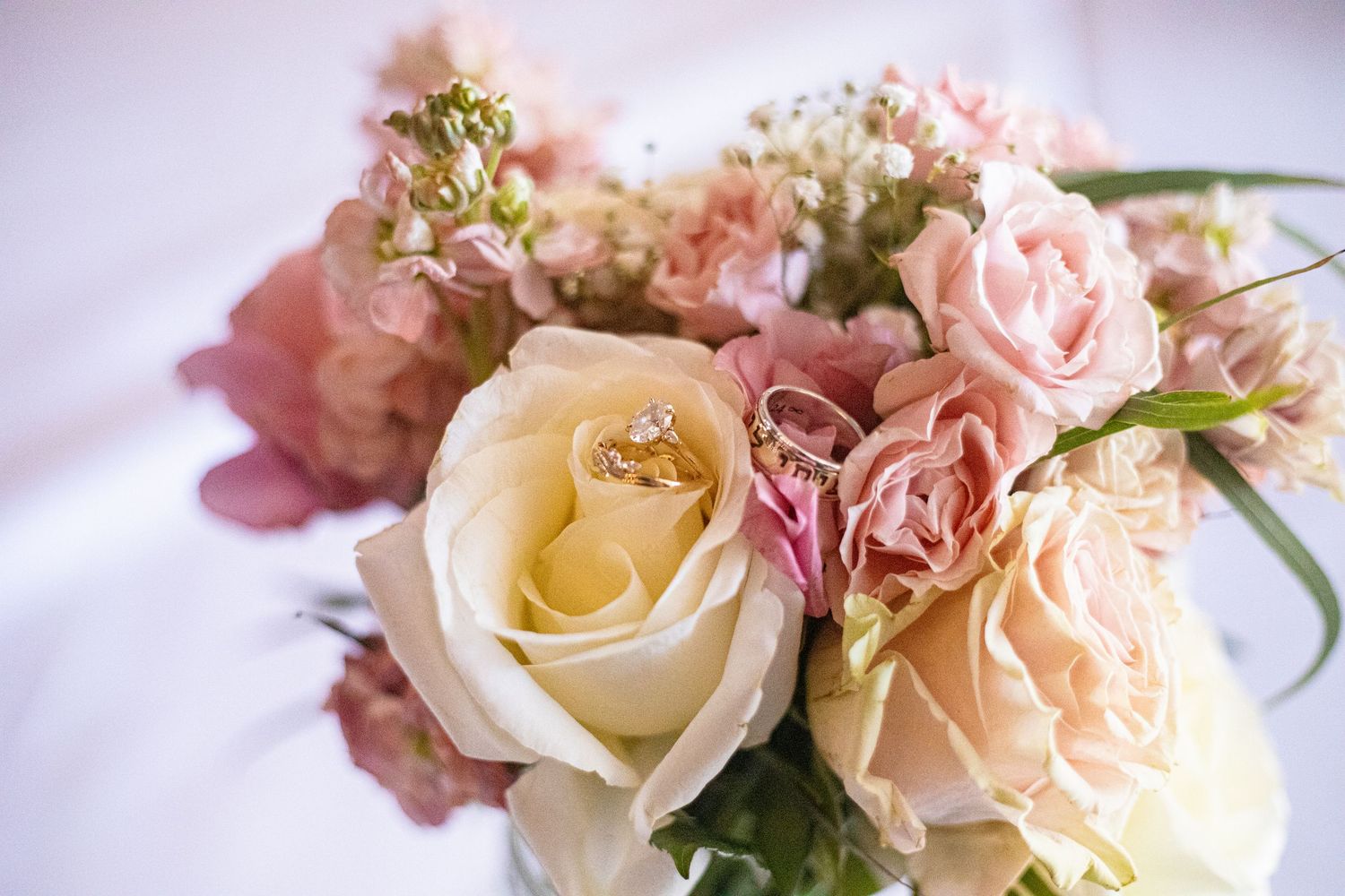 Delicate arrangement of pink and cream roses with soft romantic lighting.