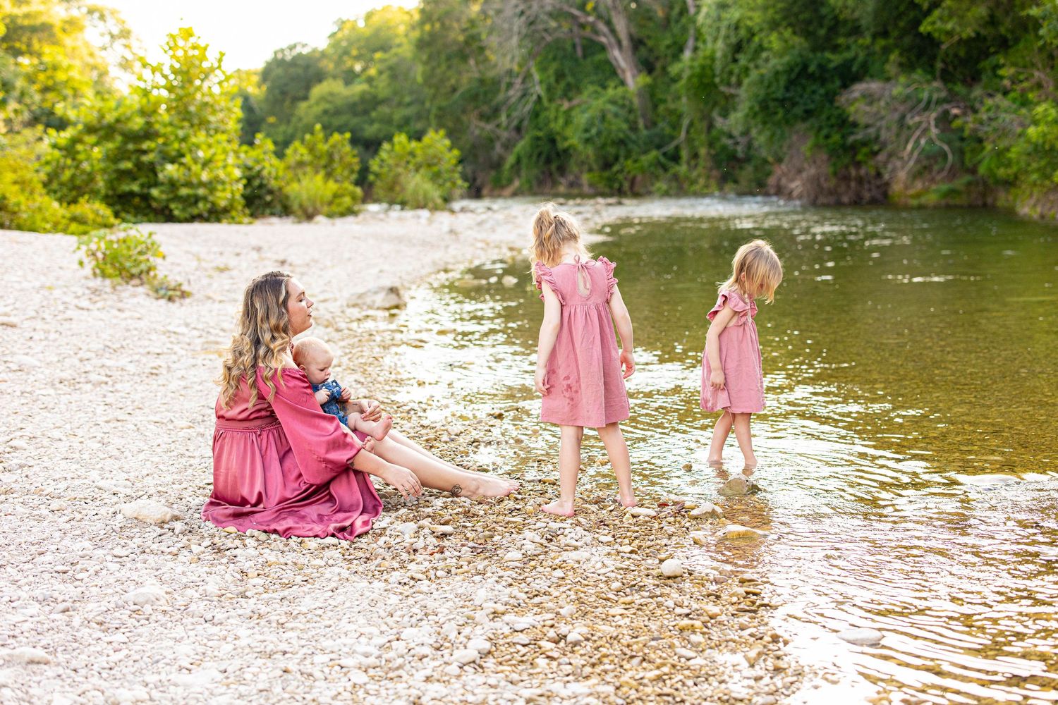 Sunset family photoshoot by a serene river with golden reflections.
