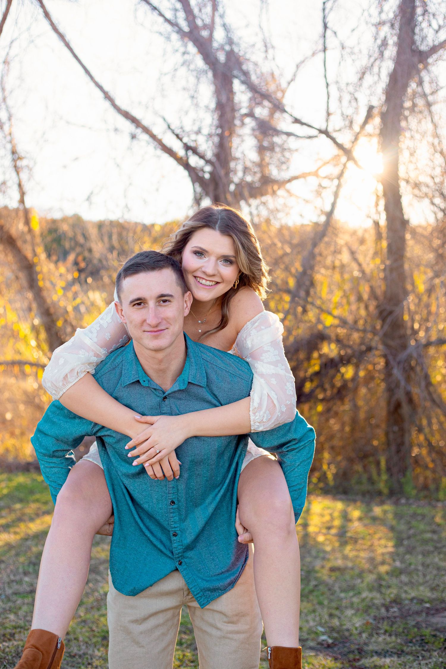 A playful piggyback pose captured during a sunset photoshoot with fall foliage.