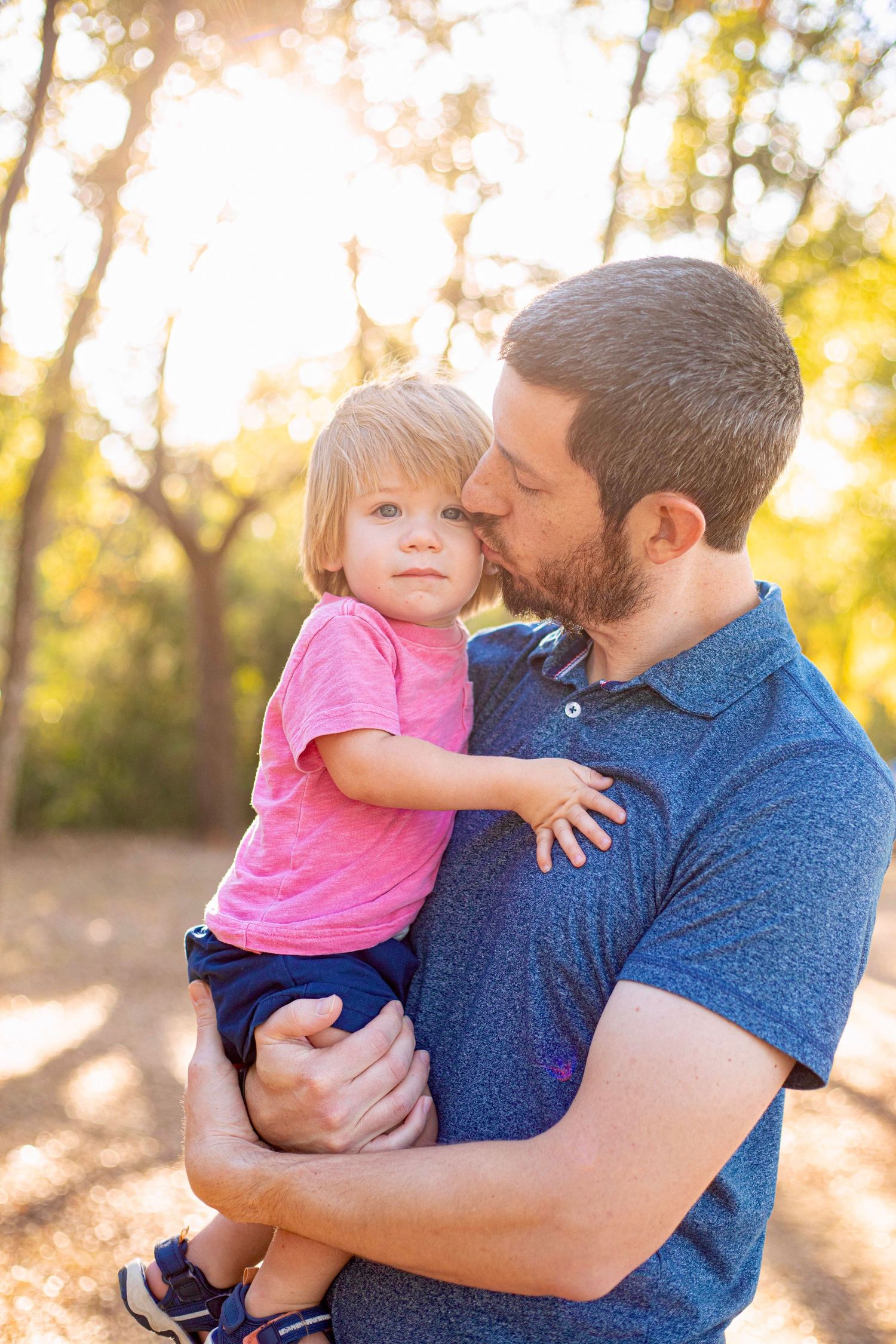 Loving embrace captured in golden hour lighting among autumn trees.