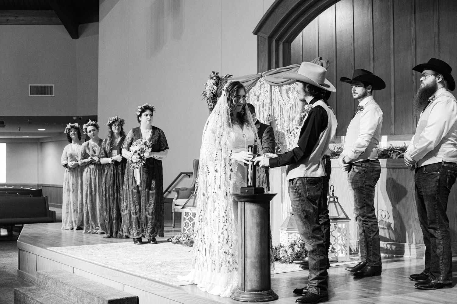 Black and white photo of wedding ceremony in traditional church setting.