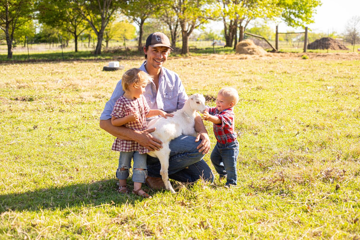 Family and white dog enjoying time together in sunny field.