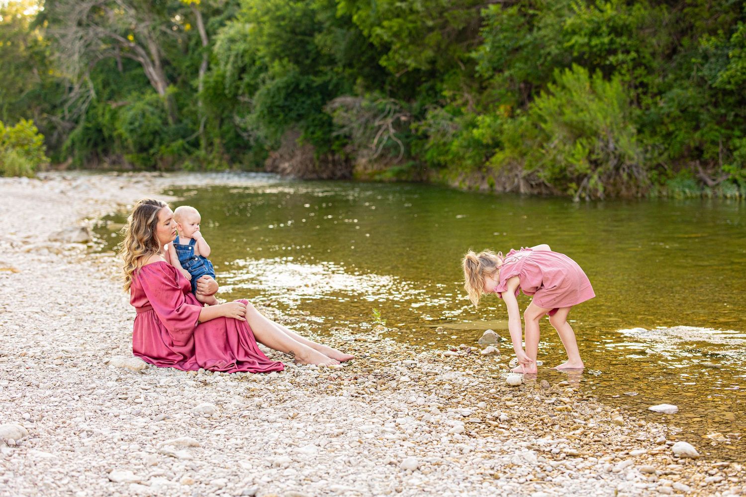 Beautiful riverside photoshoot scene with natural greenery and rocky shore.