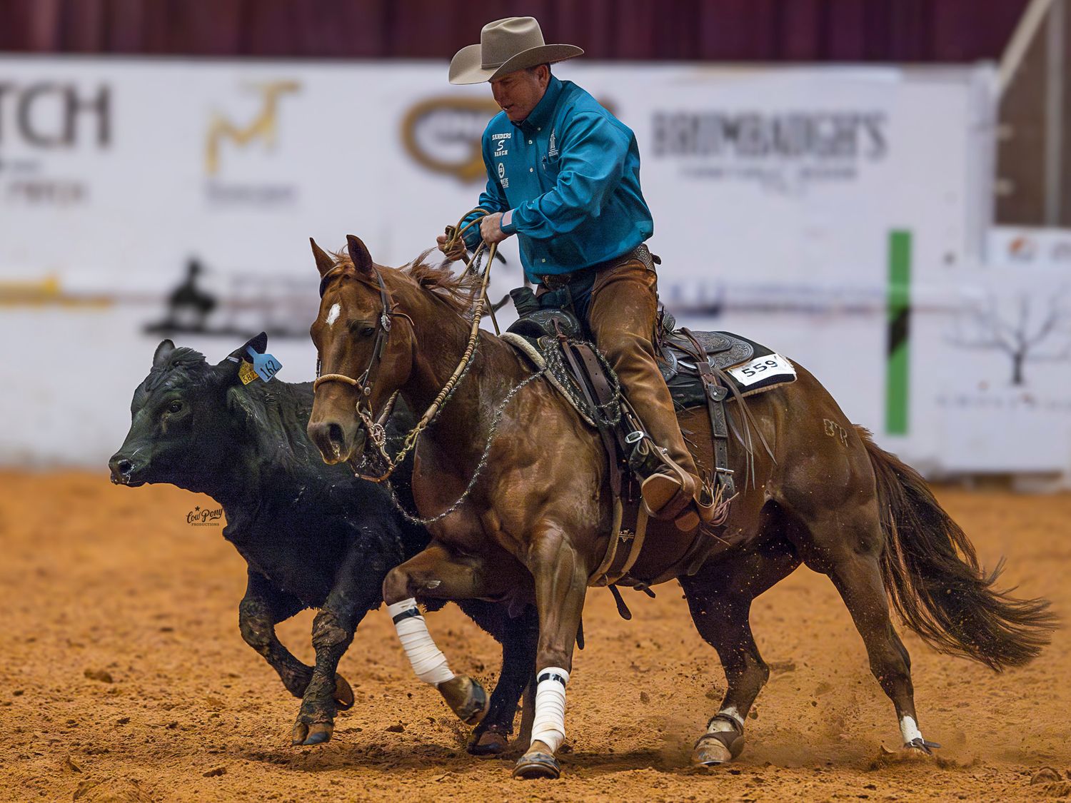 A cow horse trainer circling a cow in the Will Rogers Coliseum during the NRCHA Celebration Of Champions.