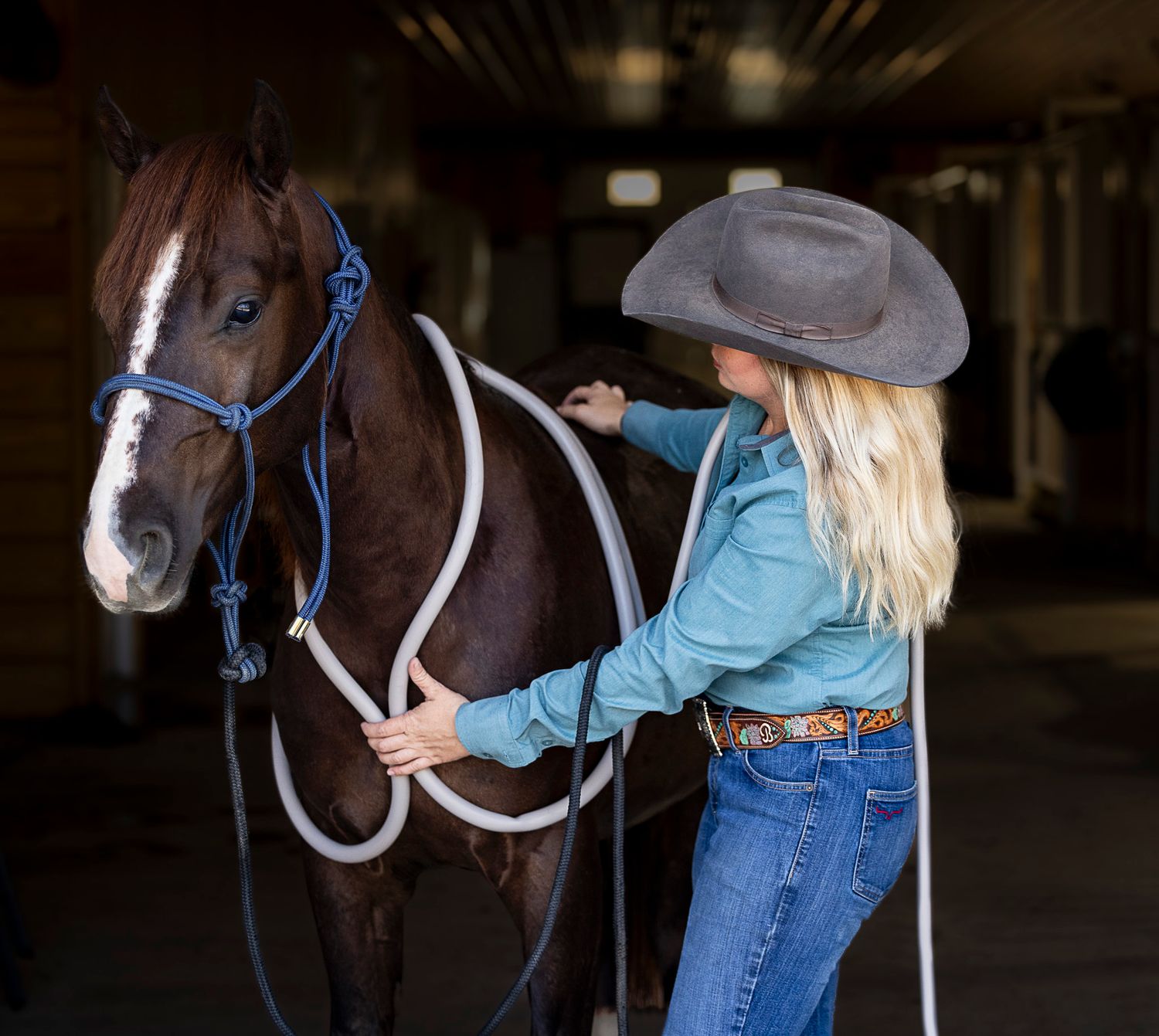 portrait of a cowgirl using a PEMF Machine on a horse