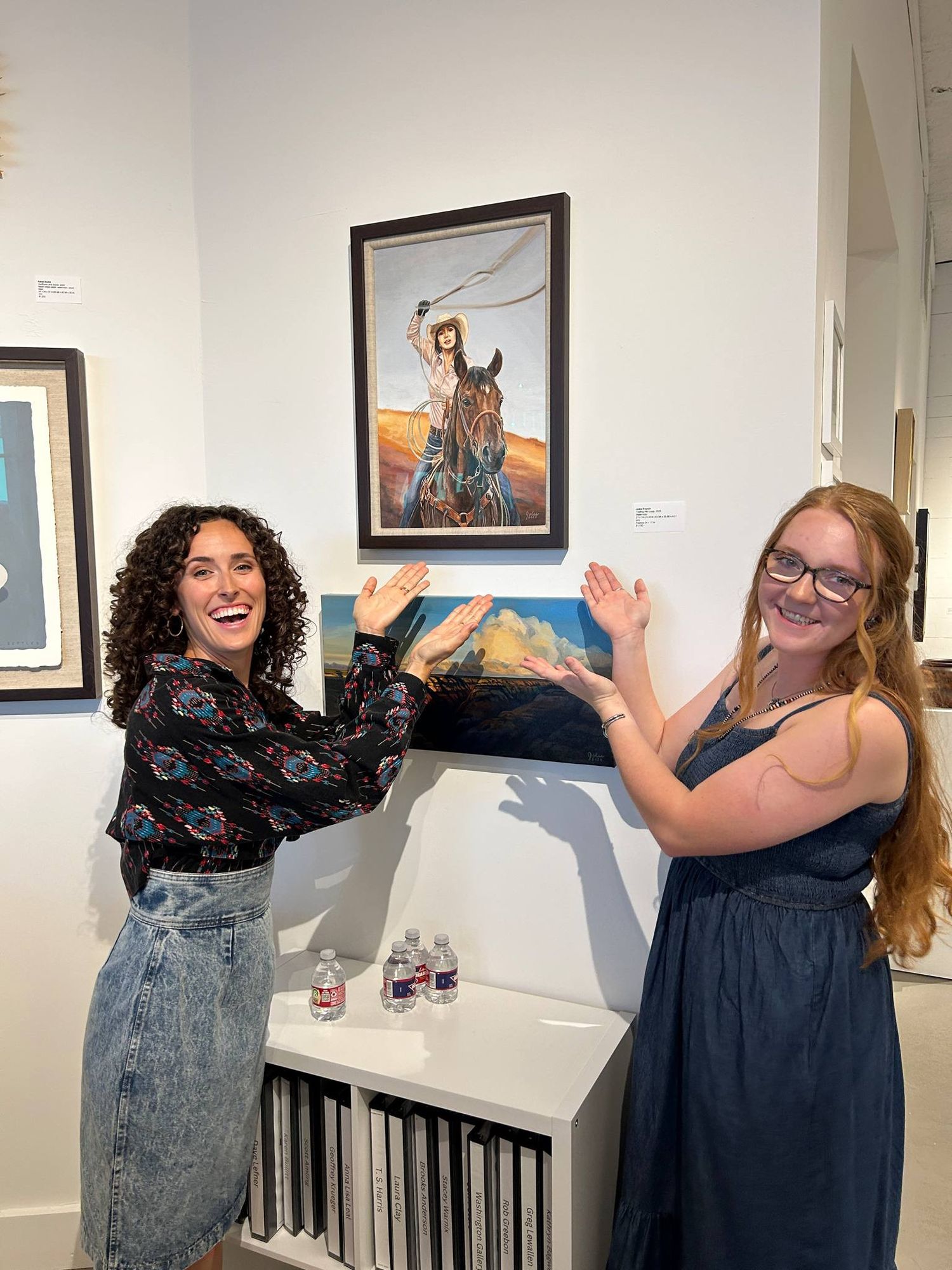 an artist and photographer admiring a painting of a roping cowgirl at the Washington Art Gallery in Waco, Texas