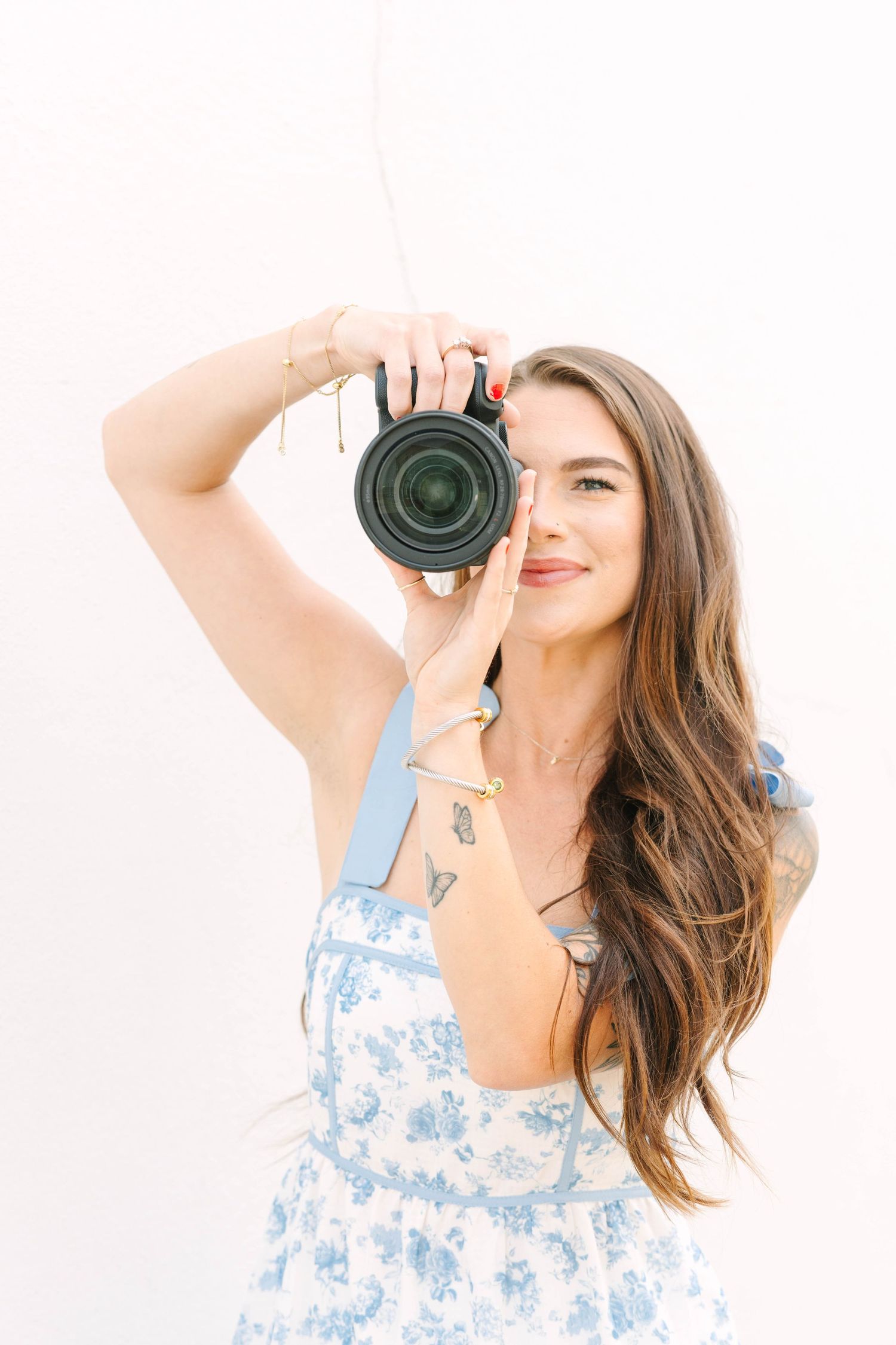 Creative portraits of photographer with camera wearing blue floral dress.