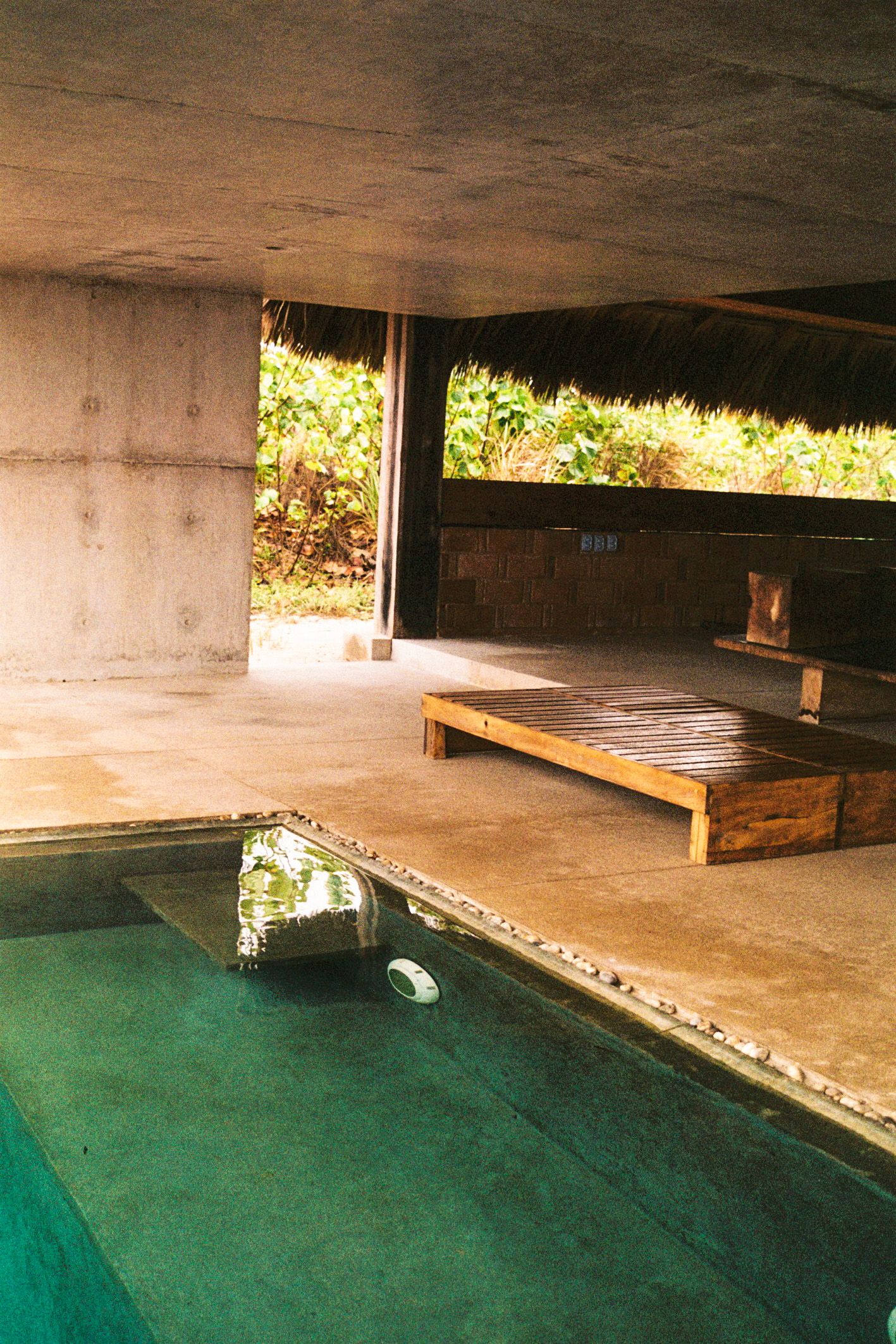 Swimming pool in Mexico, showcasing both indoor and outdoor elements. The scene captures the clear water of the pool,  shot taken with 35mm.