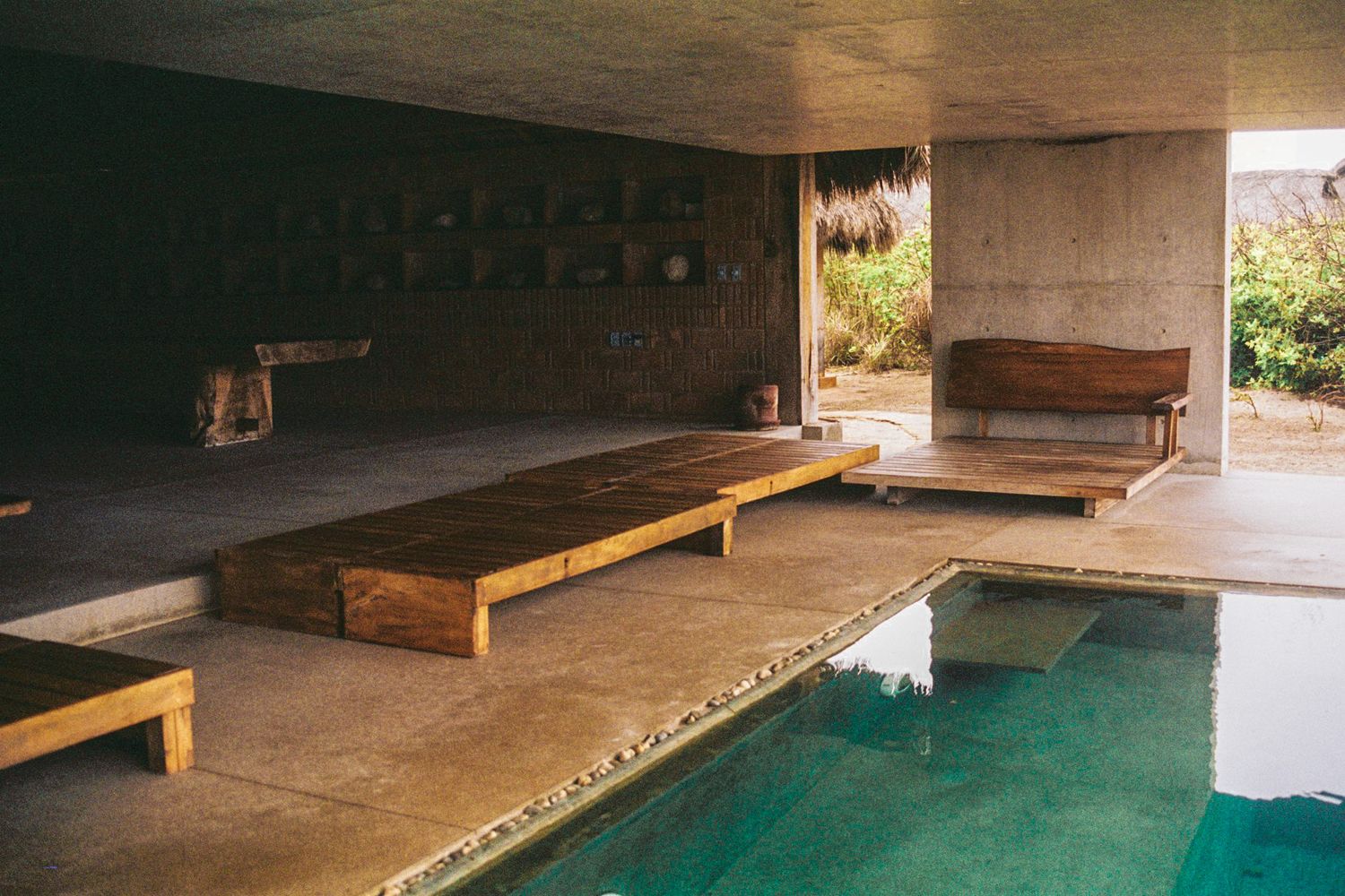Swimming pool in Mexico, showcasing both indoor and outdoor elements. The scene captures the clear water of the pool,  shot taken with 35mm.