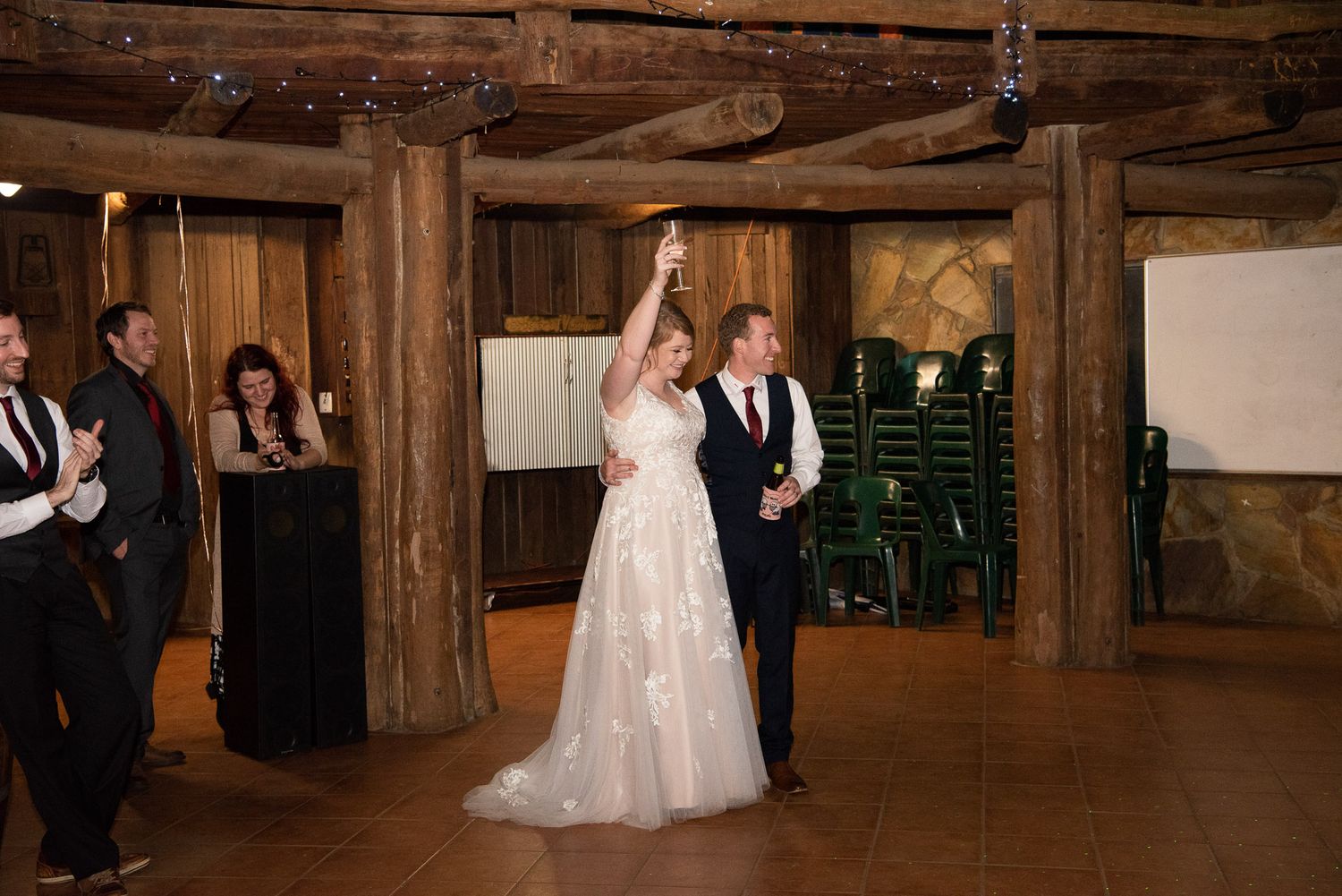Panoramic view of a rustic wooden barn wedding venue with exposed beams and ambient lighting.